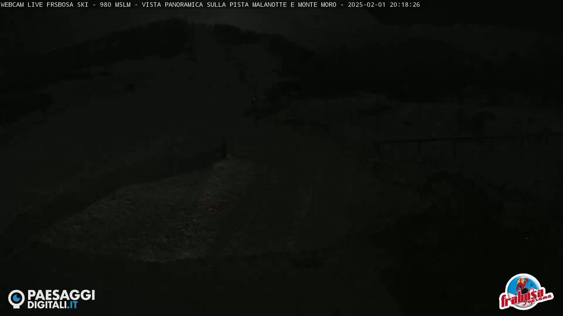 A dark, nighttime scene shows a snow-covered landscape.
