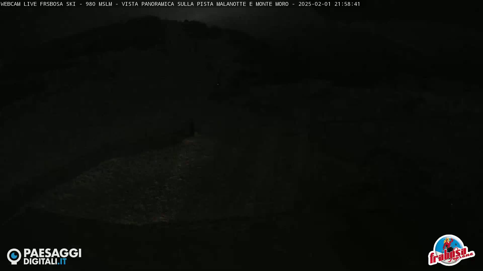A dark, nighttime view of a hilly landscape.