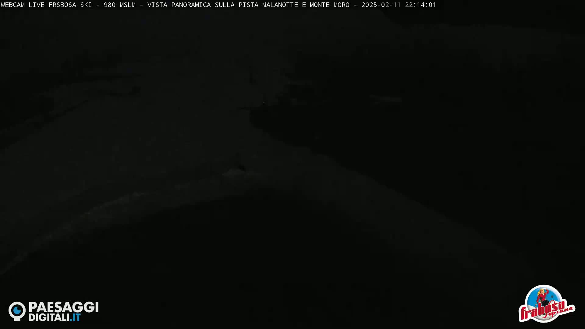 A dark, nighttime image shows a snow-covered landscape.