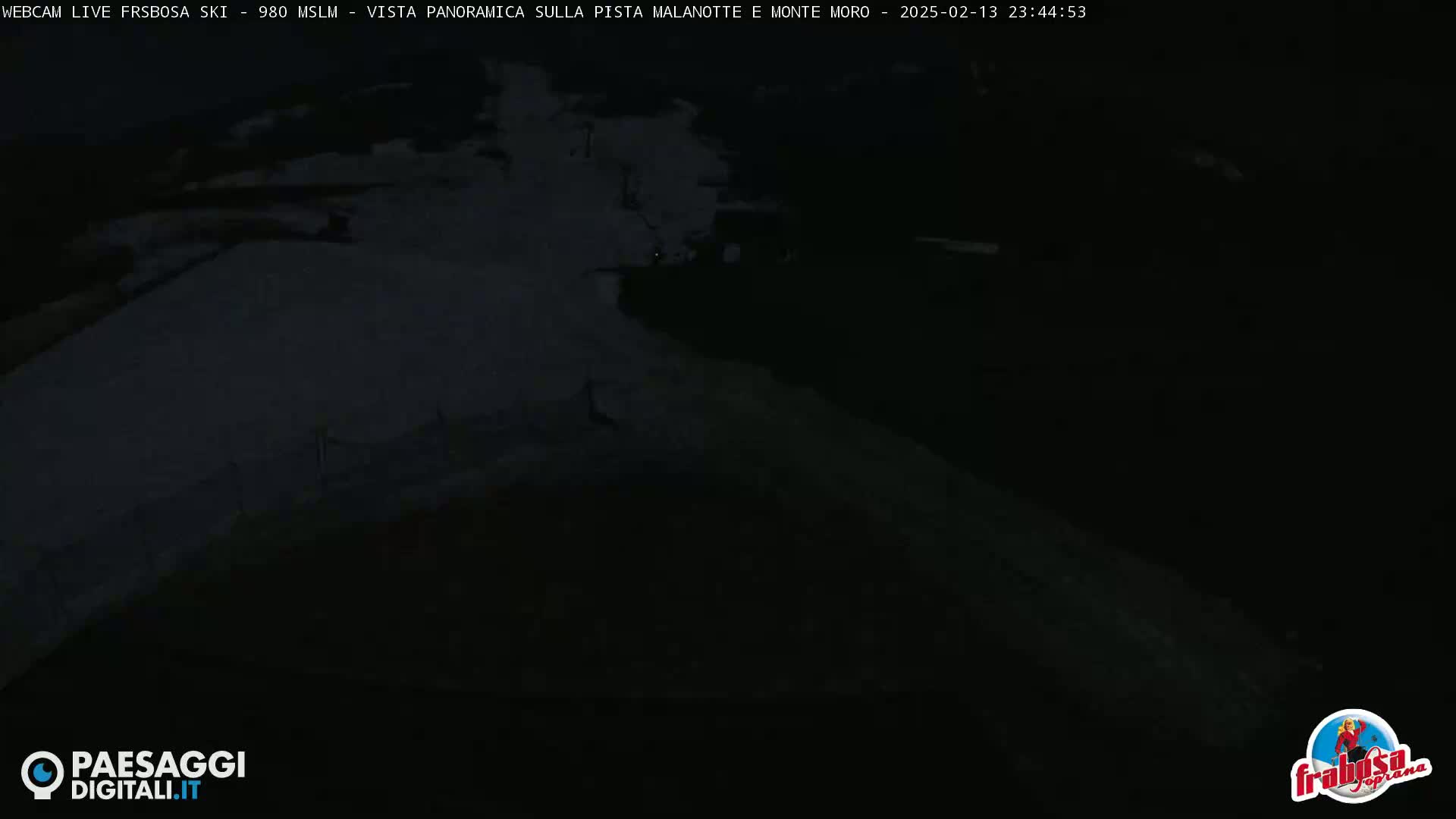 A dark, snow-covered ski slope is visible at night.