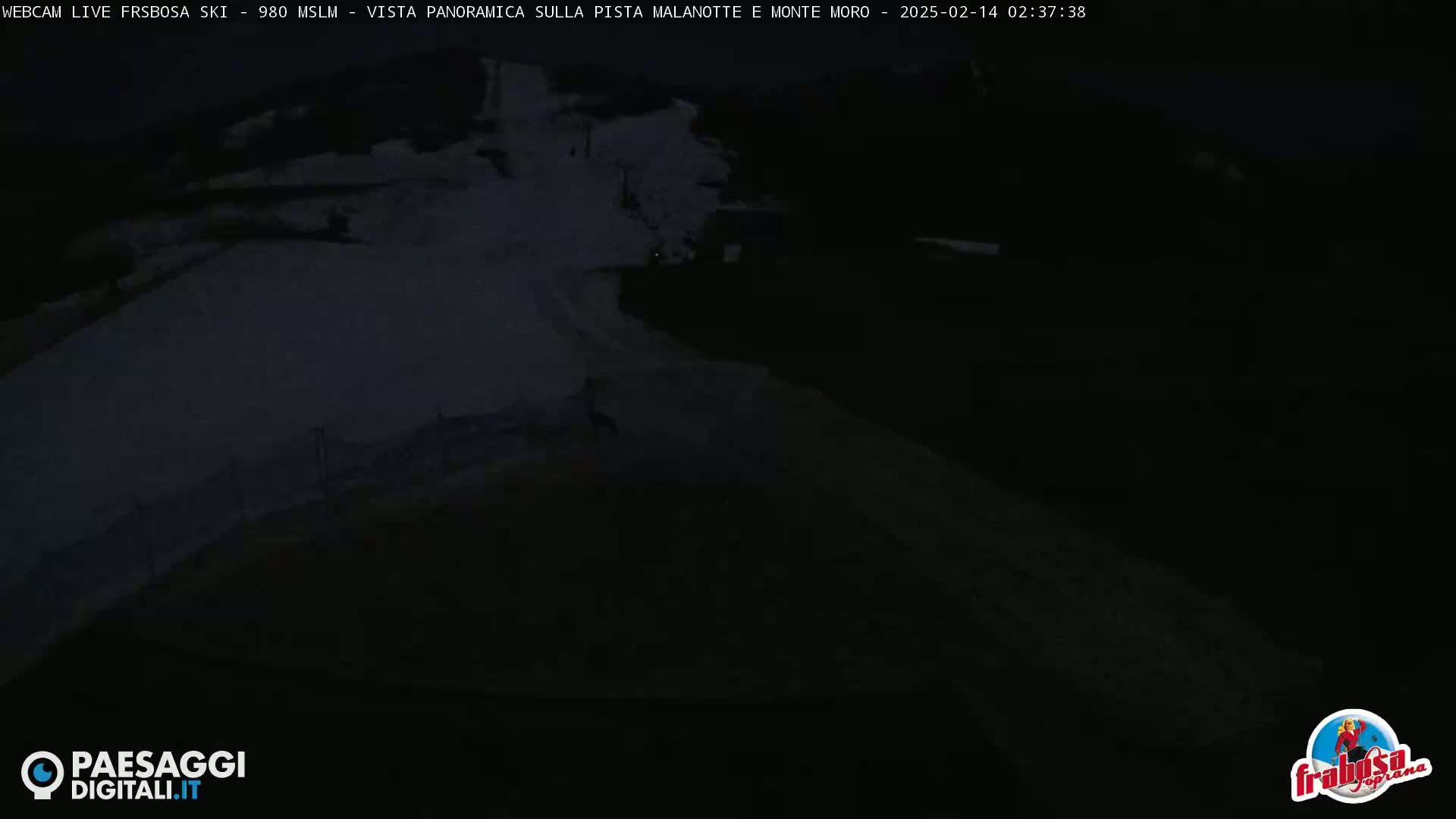 A dark, snow-covered slope is visible at night.