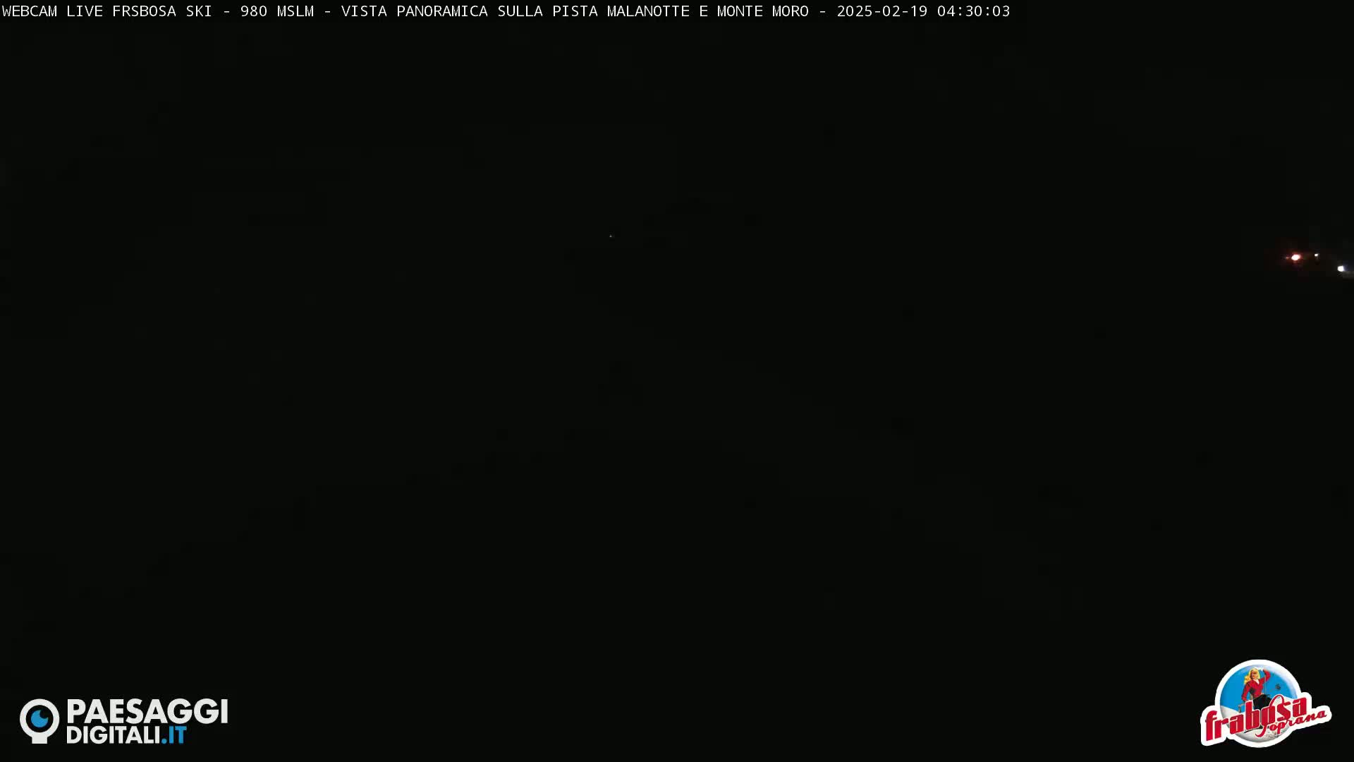 A completely dark, nighttime outdoor scene shows only a few faint lights in the far distance.