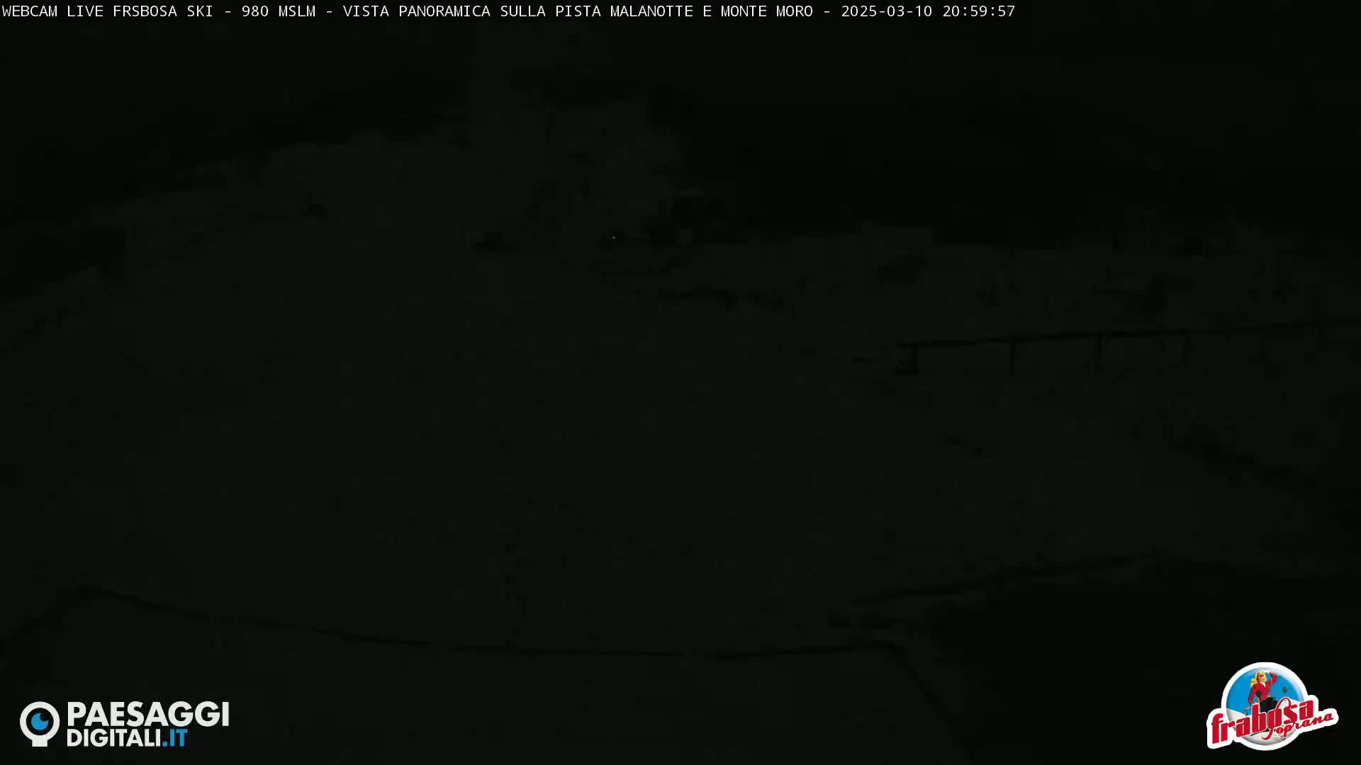 A dark, nighttime view of a snow-covered area.