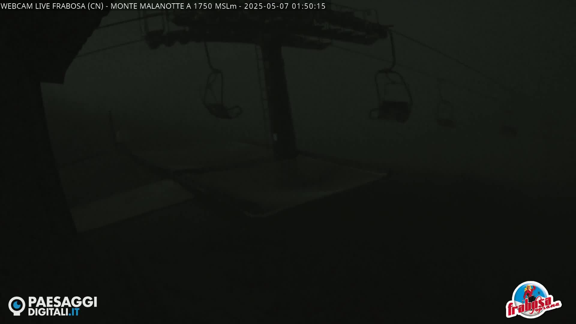 A dark, foggy scene shows an empty chairlift.