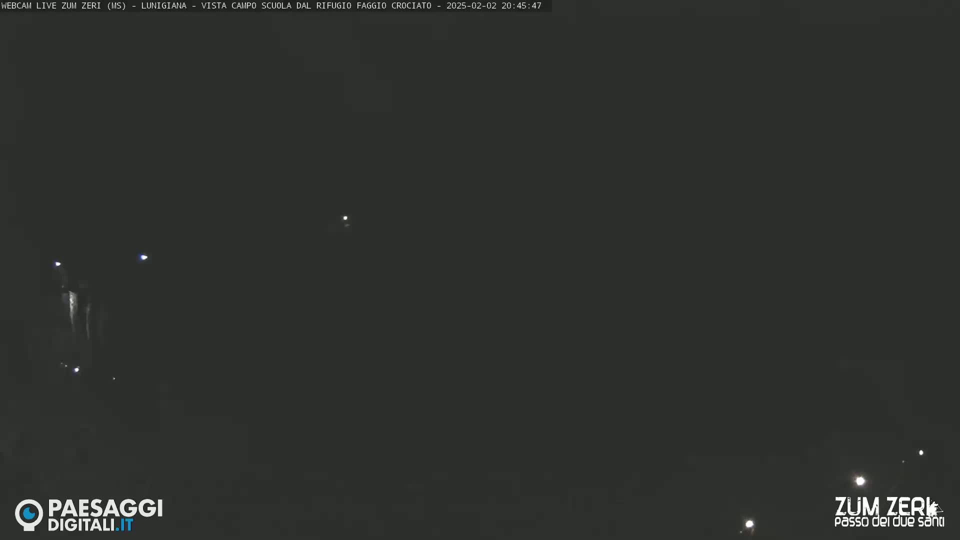 A dark, nighttime scene shows a few distant lights.