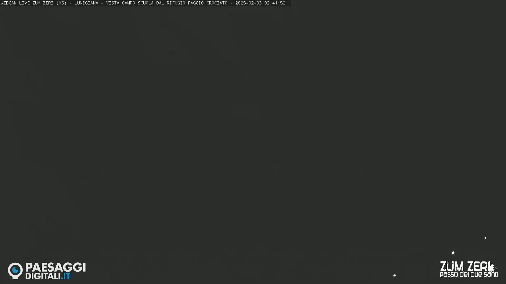 A dark, nighttime image shows a mostly black sky with a few faint white specks.