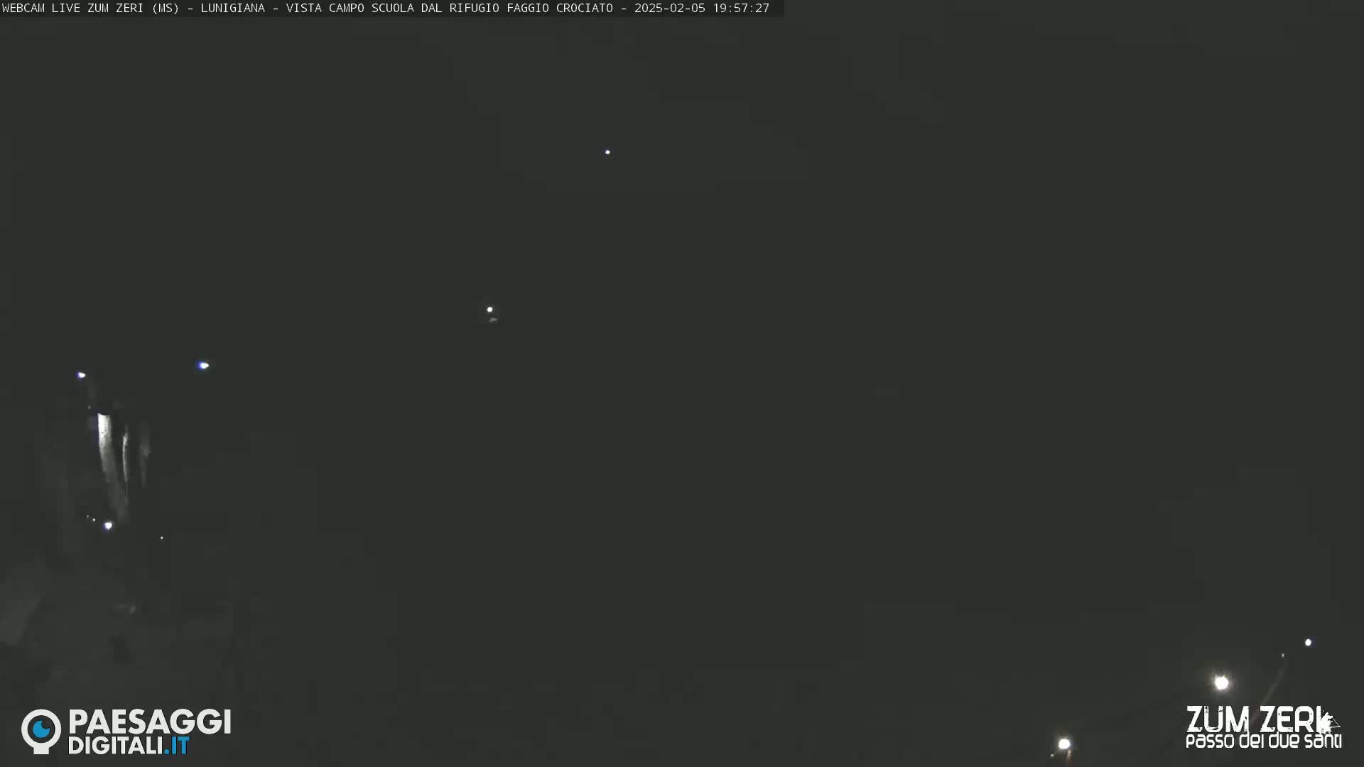 A nighttime outdoor scene shows a dark sky with a few distant lights visible.