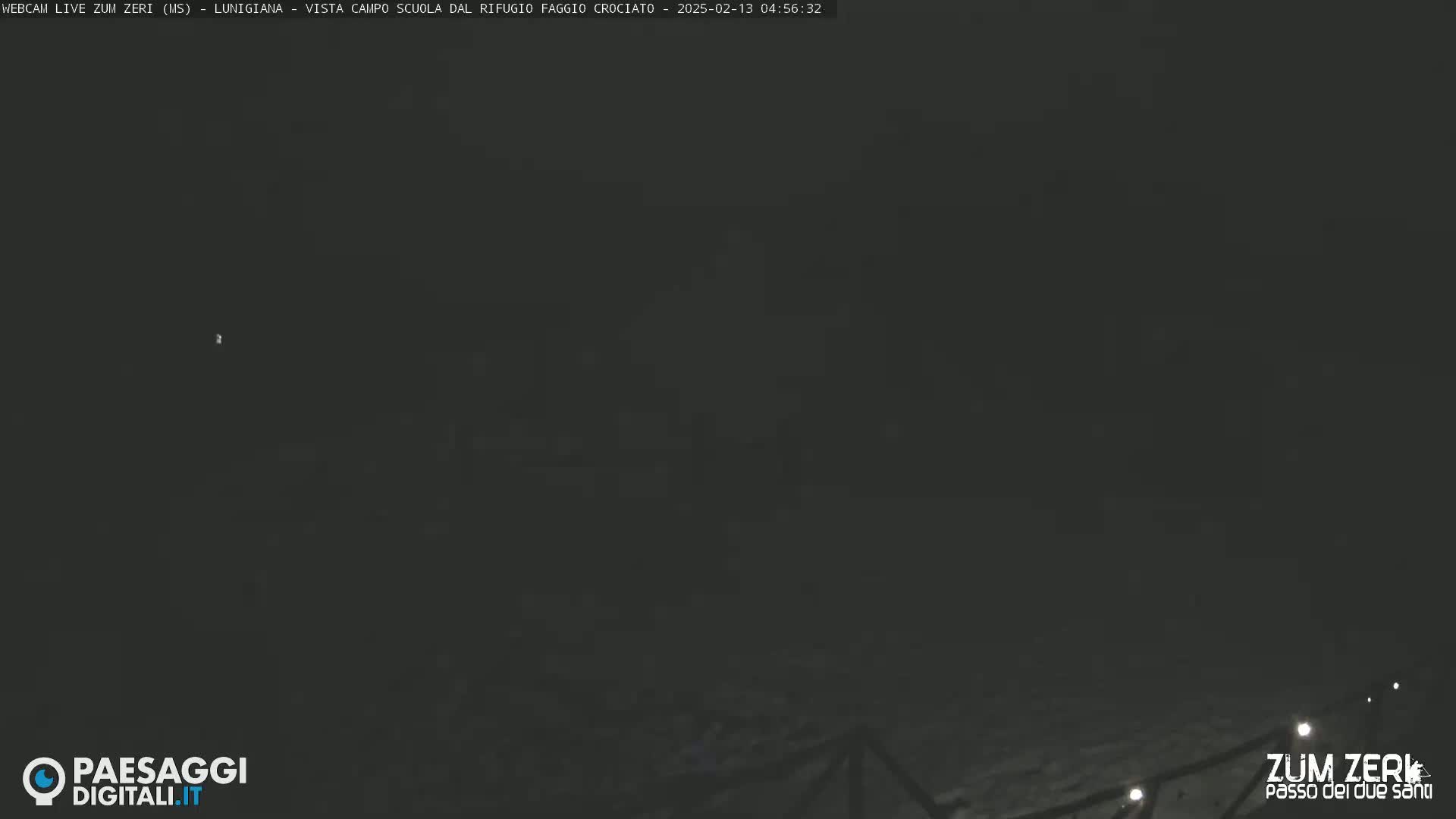 A dark, nighttime outdoor scene shows a blurry, indistinct landscape under a mostly clear sky.