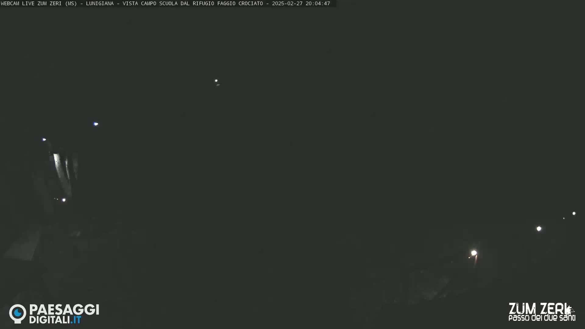 A nighttime, outdoor scene showing faint lights in the distance.