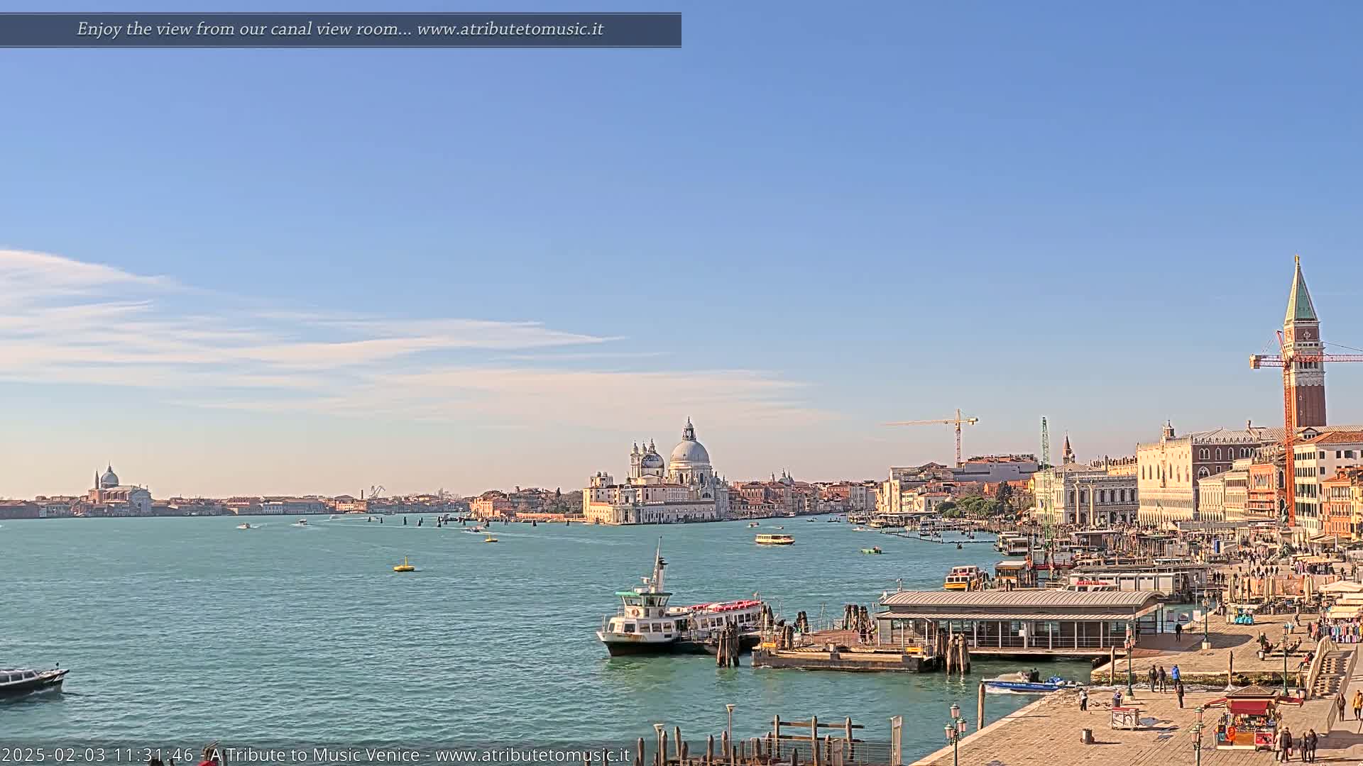 A clear, sunny day reveals a Venetian canal scene with boats, a water taxi station, and the Basilica di Santa Maria della Salute in the distance.