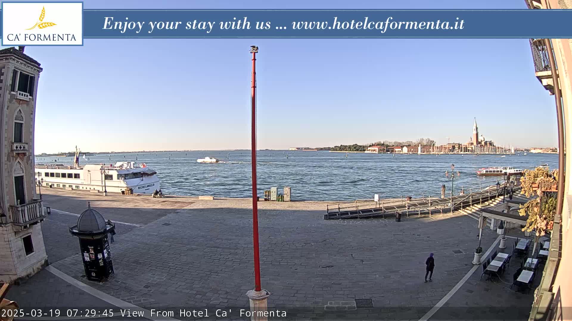 A waterfront paved area shows a docked cruise ship and distant Venetian buildings under a clear, sunny sky.