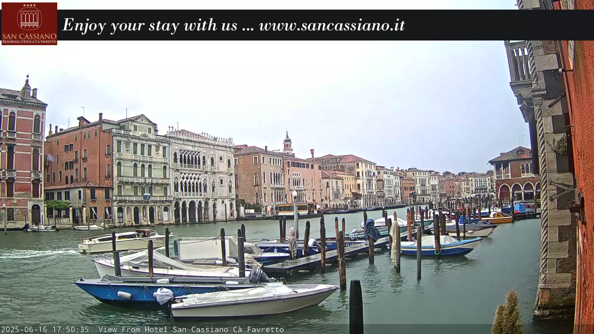 A canal in Venice, under a cloudy sky, is lined with docked boats and historic buildings.