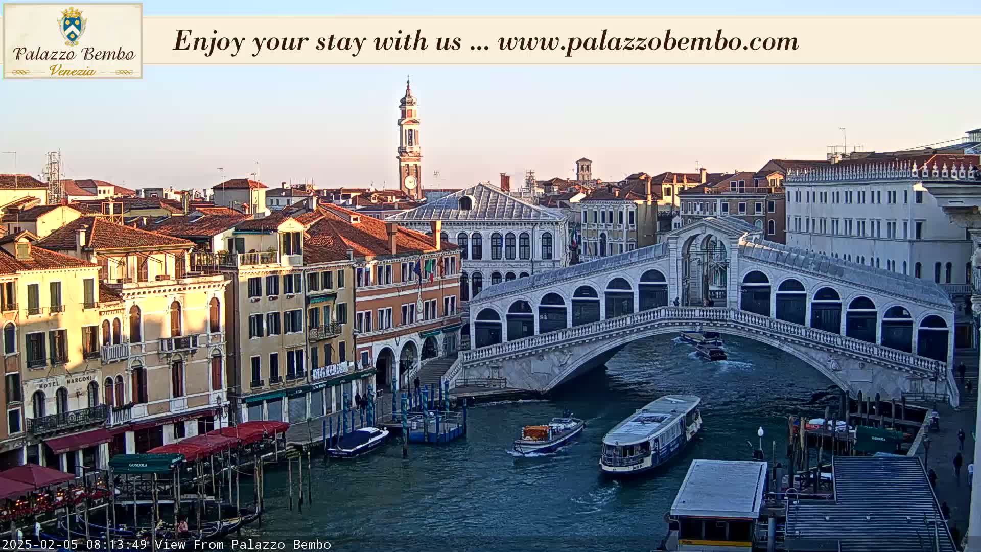 A Venetian canal scene at sunrise shows the Rialto Bridge with boats passing underneath, and buildings lining the waterway.