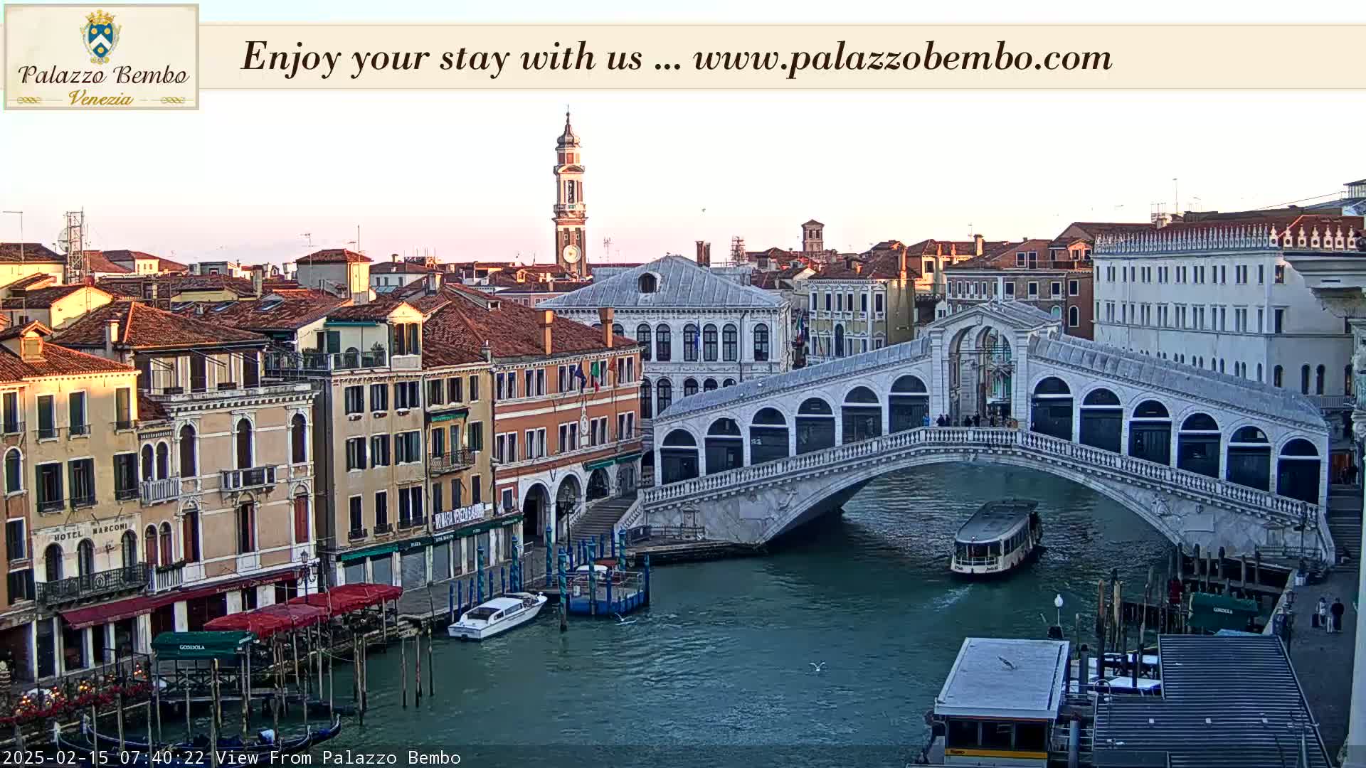 A Venetian canal scene at sunrise shows the Rialto Bridge and colorful buildings lining the waterway, with boats moored along the canals.