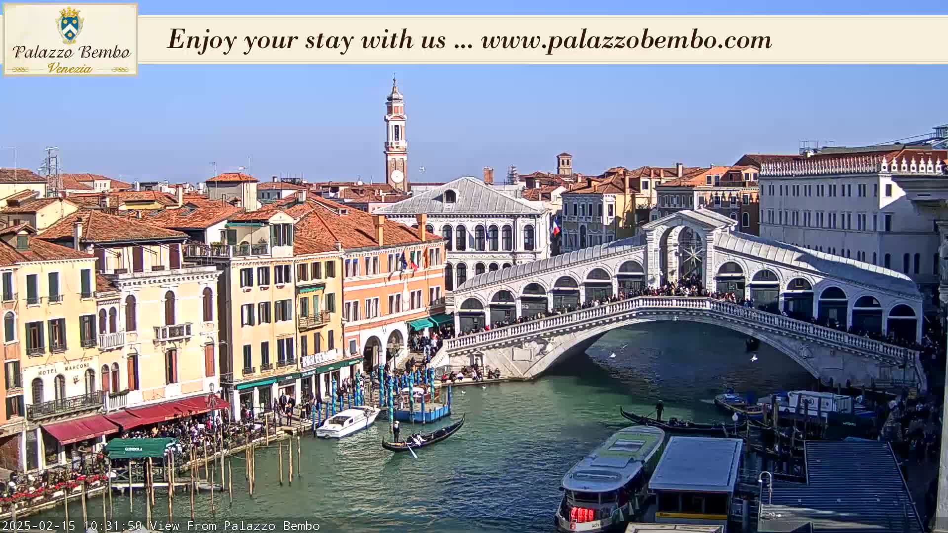 A sunny day in Venice shows a canal with gondolas, a bridge crowded with people, and colorful buildings lining the waterway.