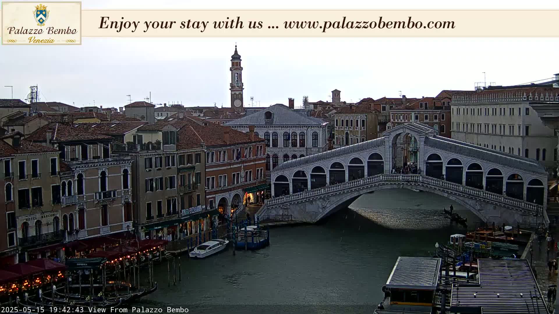 A view of a bridge over a canal in Venice, Italy, under an overcast sky.