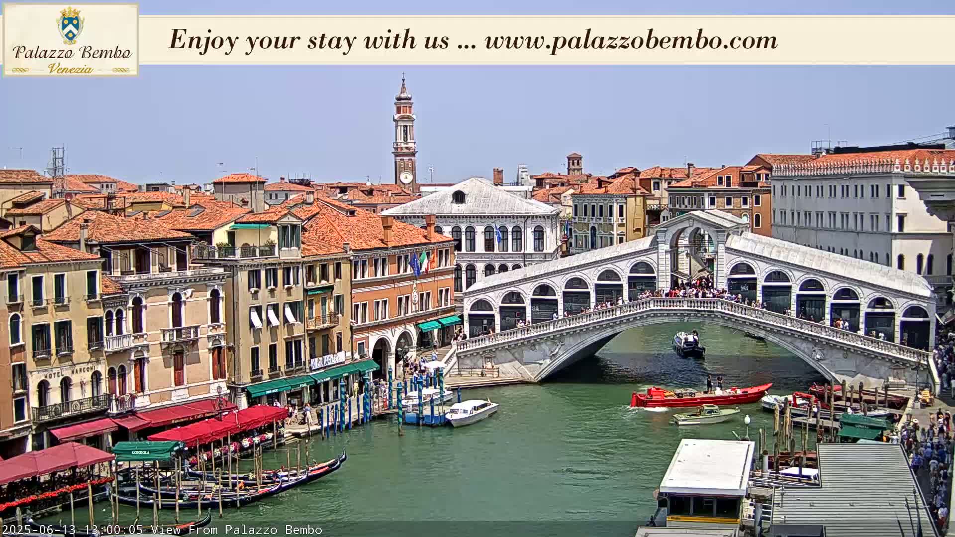 A sunny day in Venice shows a canal with gondolas, boats, and the Rialto Bridge crowded with people.