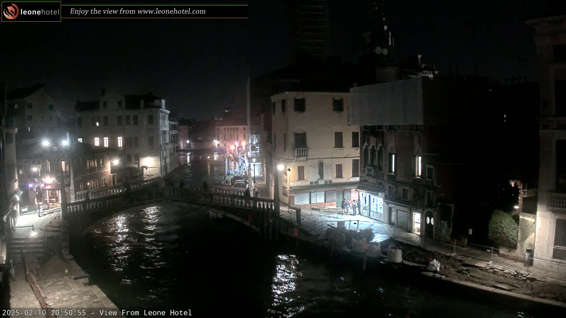 A nighttime view of a canal in Venice, Italy, showing buildings lining the waterway under dark, clear skies.