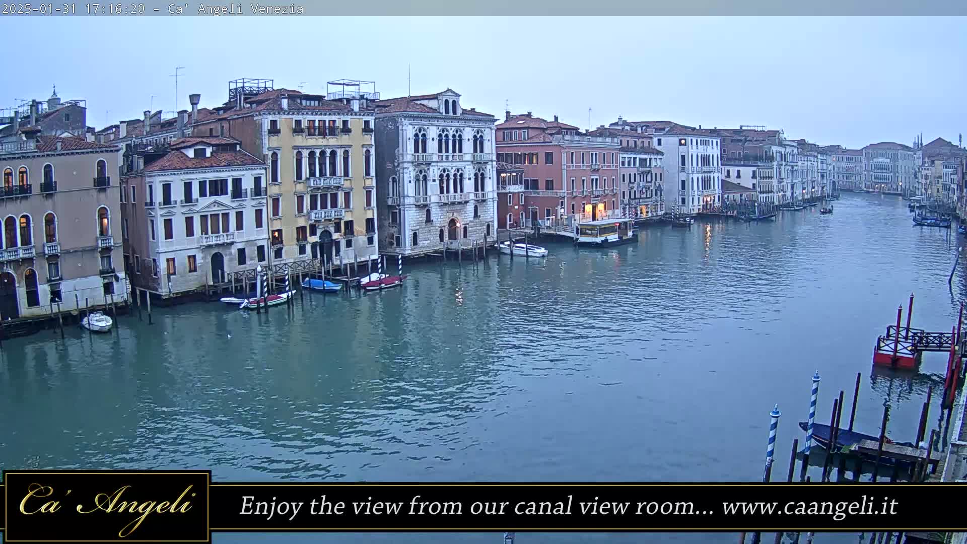A wide, calm canal in Venice, Italy, is lined with historic buildings under a dusky sky.