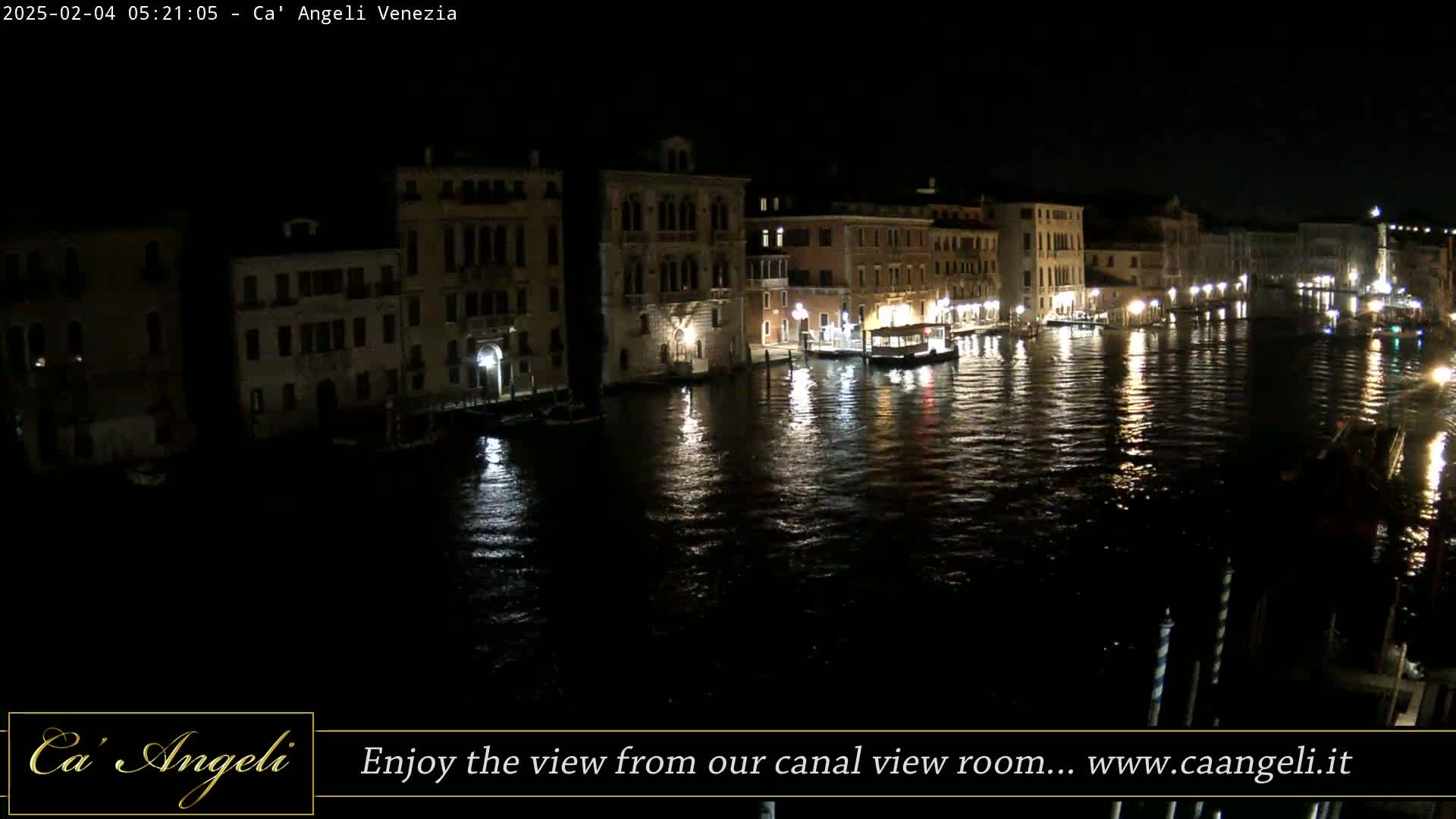 Nighttime view of a canal in Venice, Italy, with illuminated buildings lining the waterway.