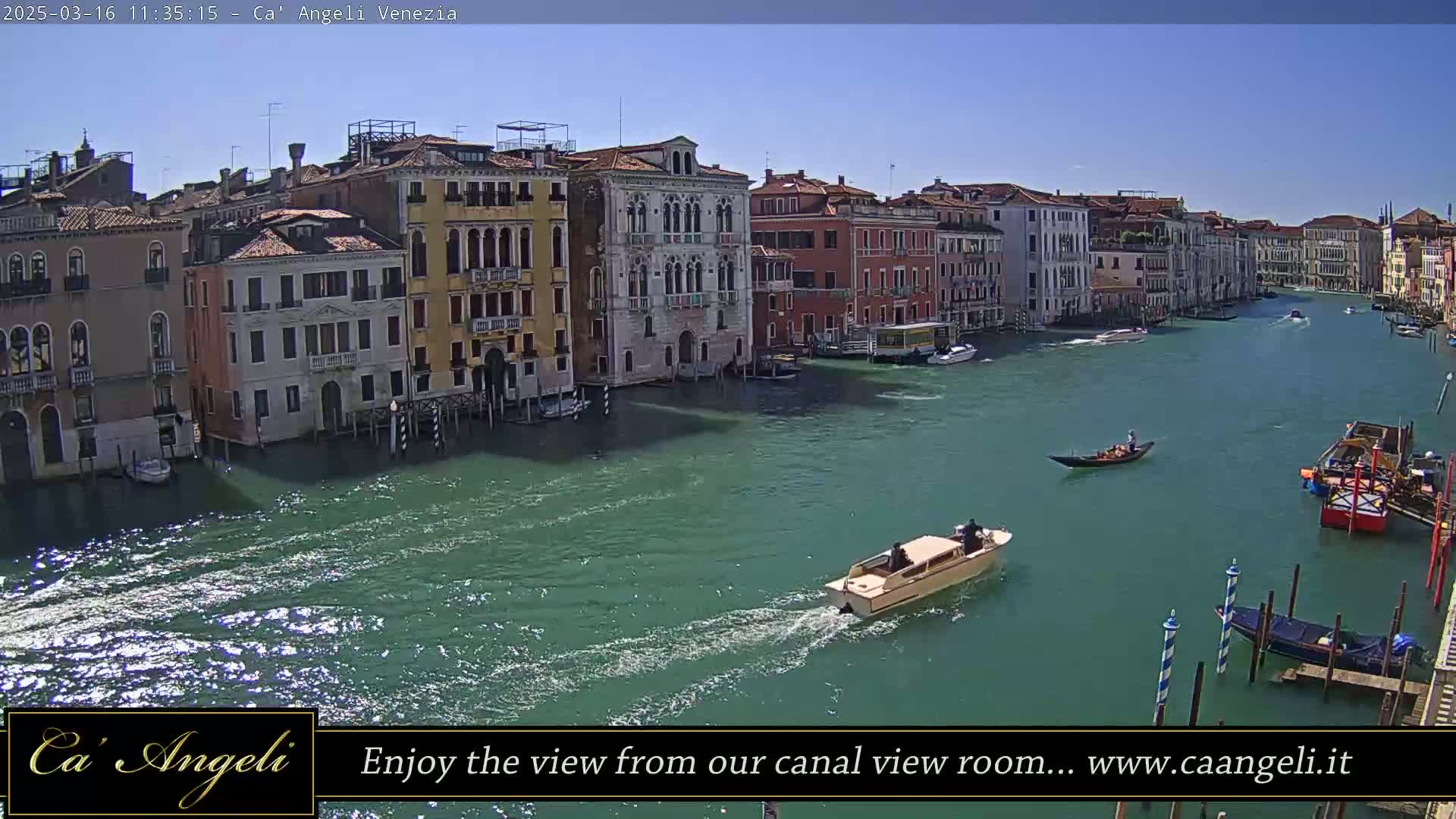 A sunny day shows a canal in Venice, Italy, with several boats and buildings lining the waterway.