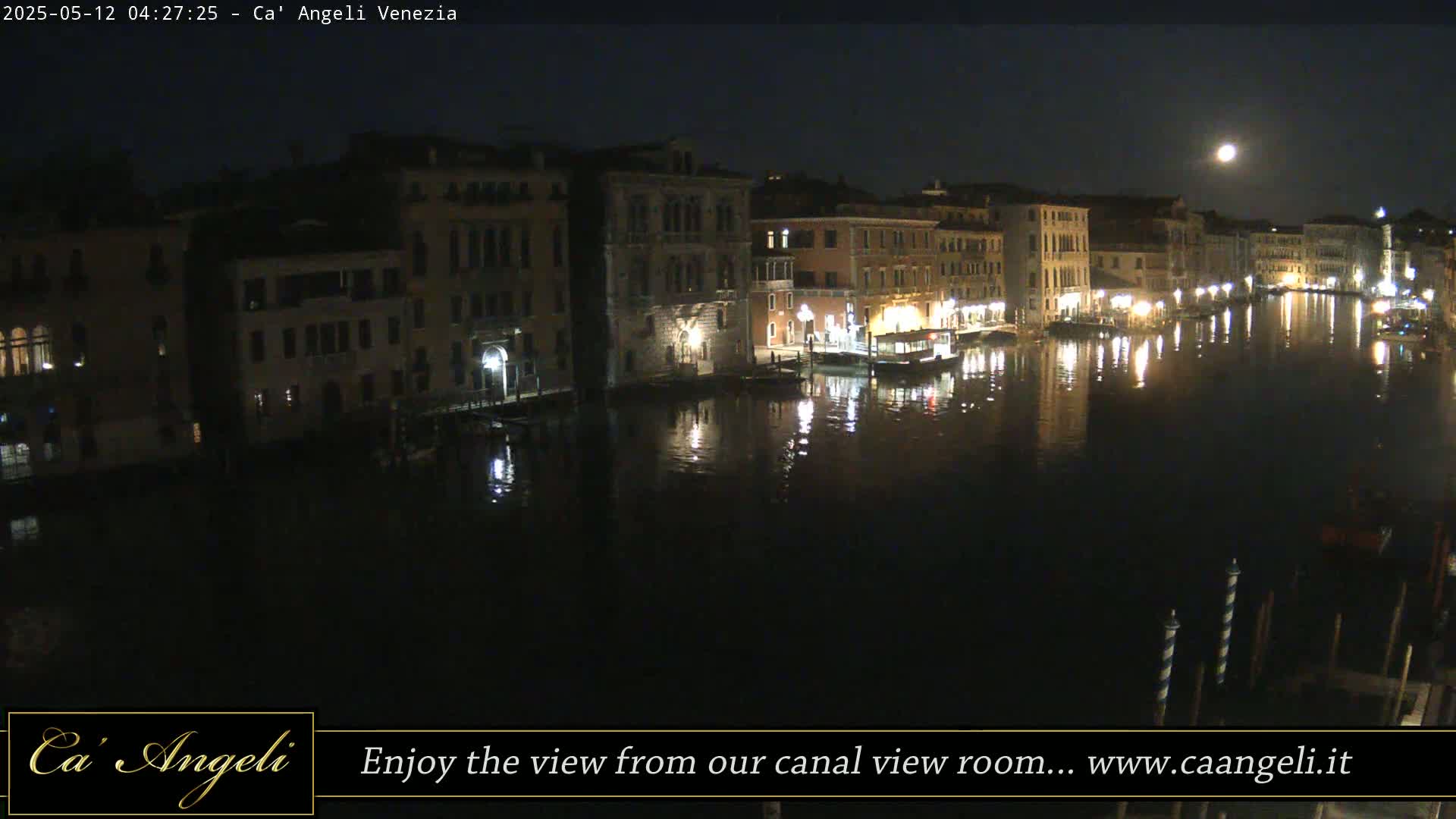 A moonlit canal in Venice, Italy, at night, shows buildings lining the waterway, reflecting in the dark water.