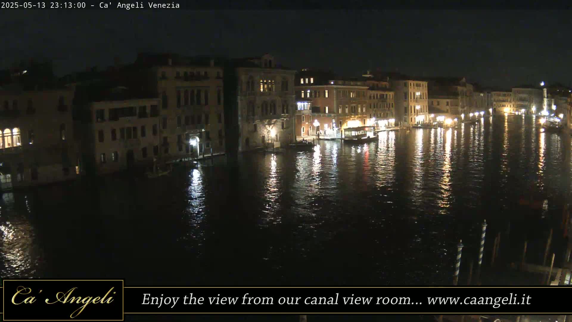 At night, illuminated buildings line a calm canal reflecting the city lights.