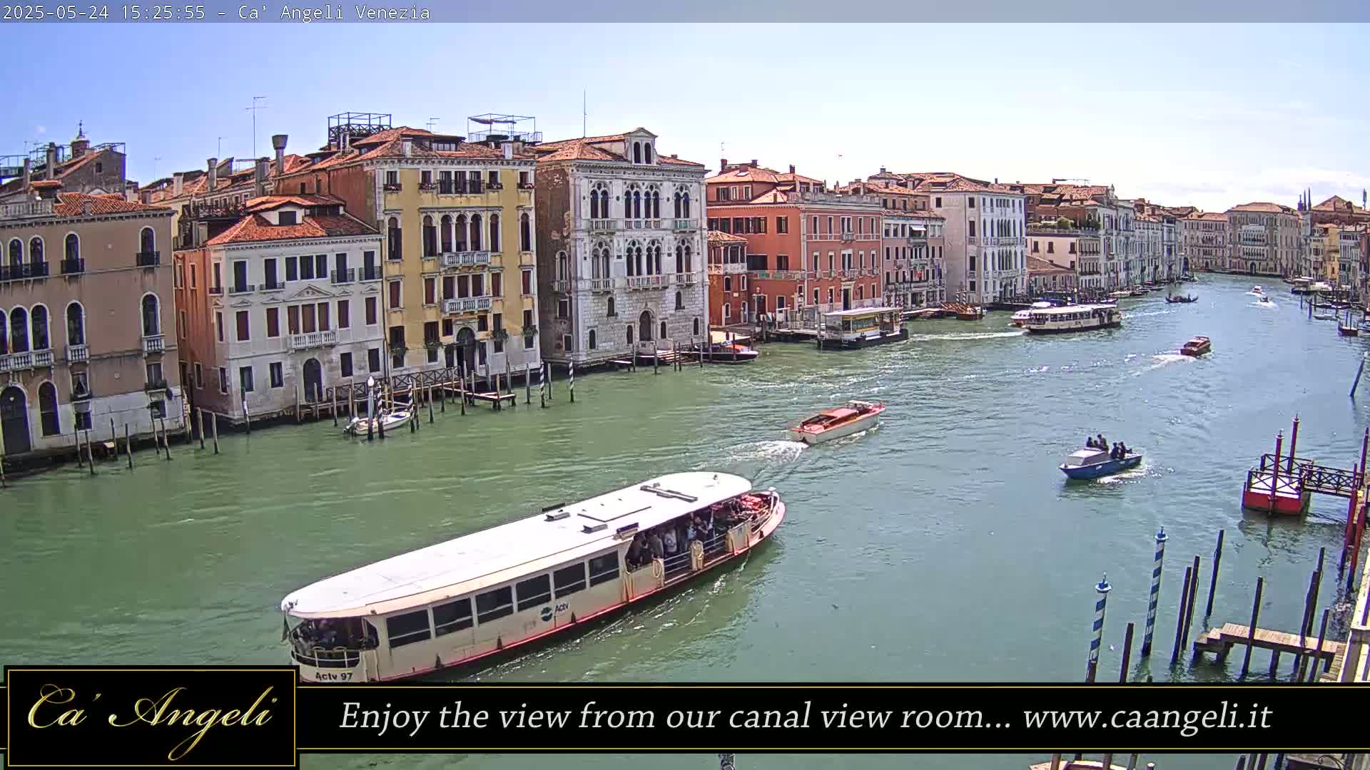 A sunny day in Venice shows a canal with several boats, including a large passenger ferry, passing by buildings along the waterway.