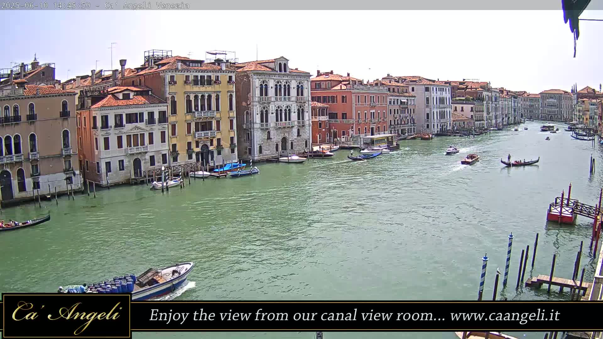 A sunny day in Venice shows a canal lined with buildings, boats, and gondolas.
