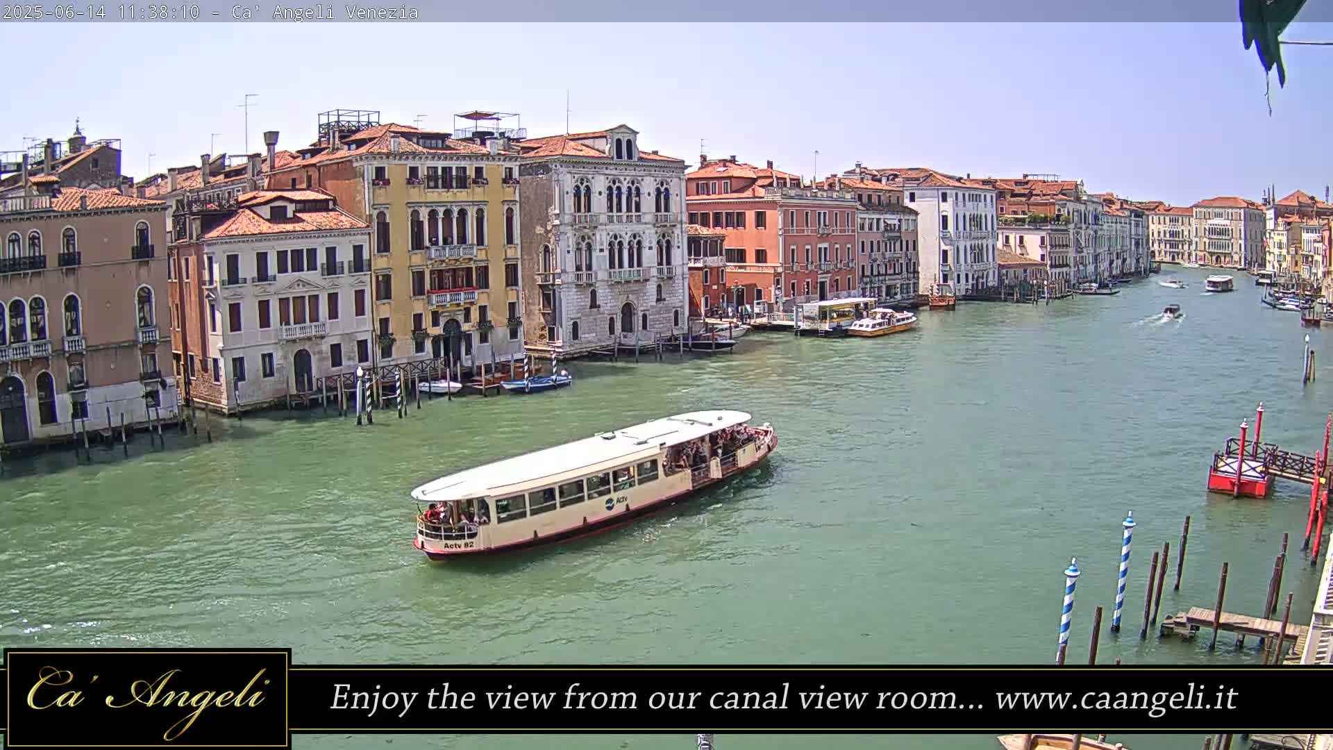 A waterway in Venice, Italy, on a sunny day, shows numerous buildings lining the canal and a passenger water-taxi traversing the water.