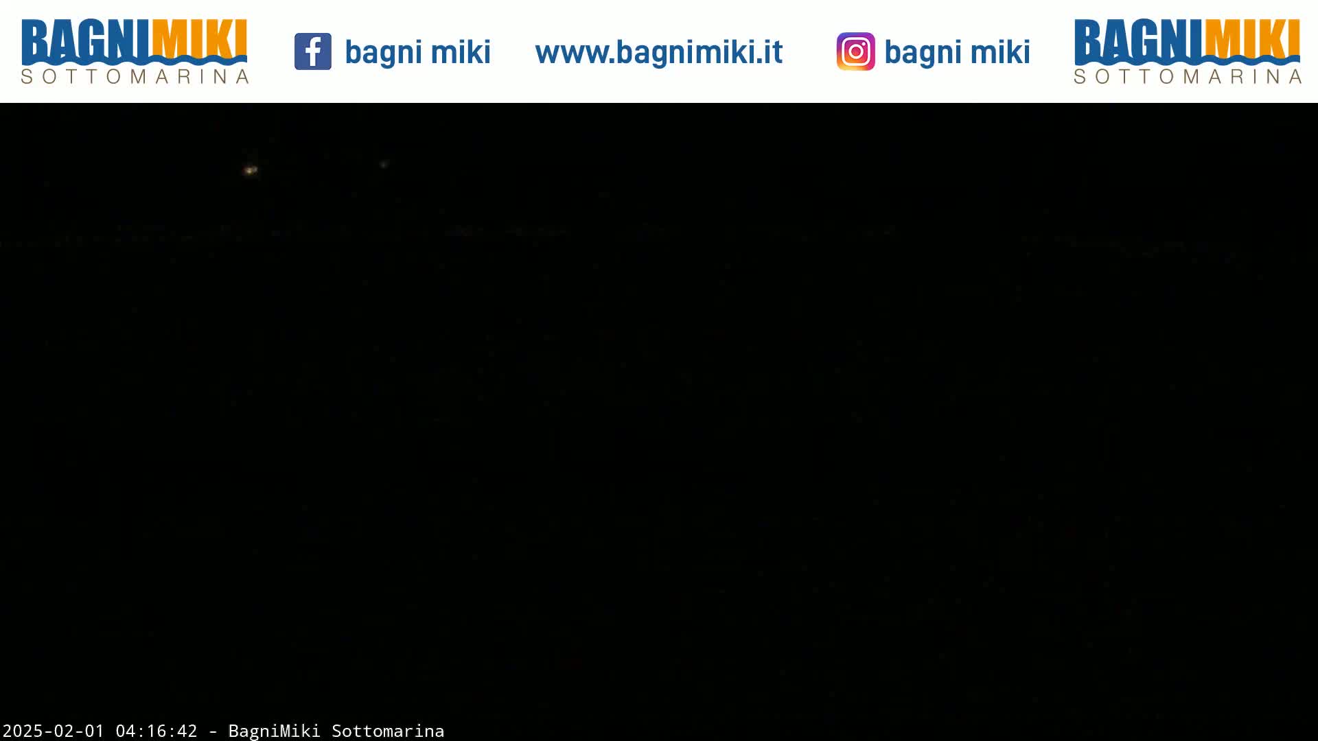 A nighttime view shows a very dark scene with two faint lights visible in the distance.