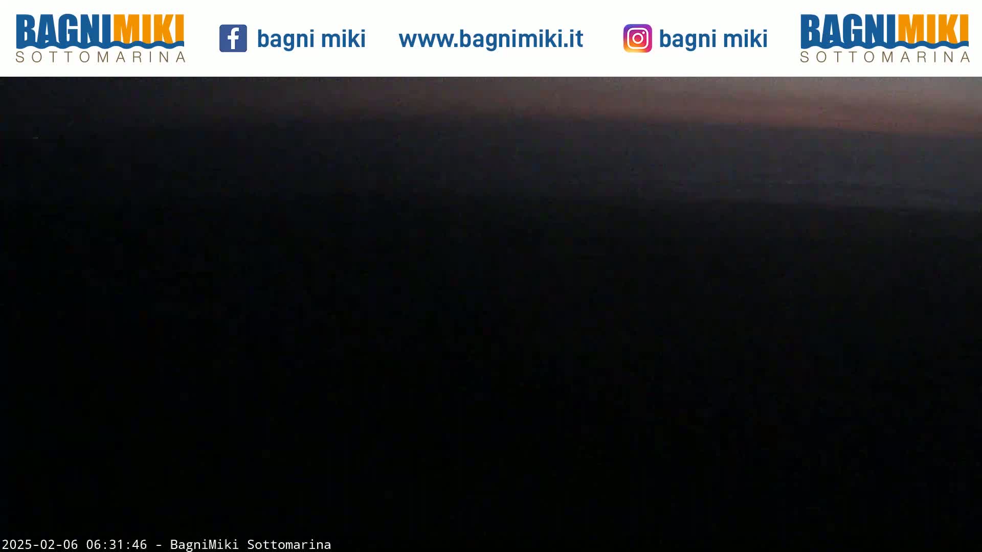 A dark, possibly pre-dawn, view of a mostly dark landscape with a faint, lighter horizon line.
