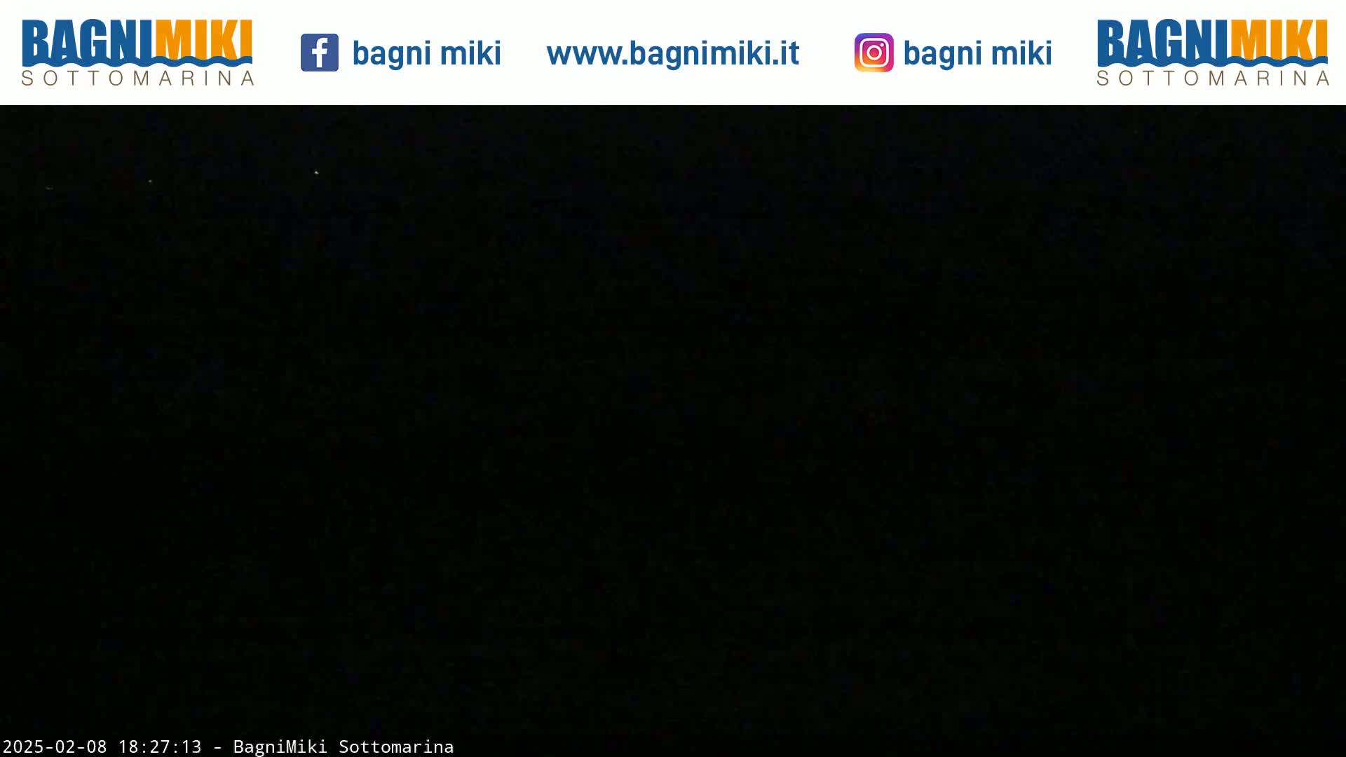 A completely dark nighttime scene is visible with a few faint lights in the distance.