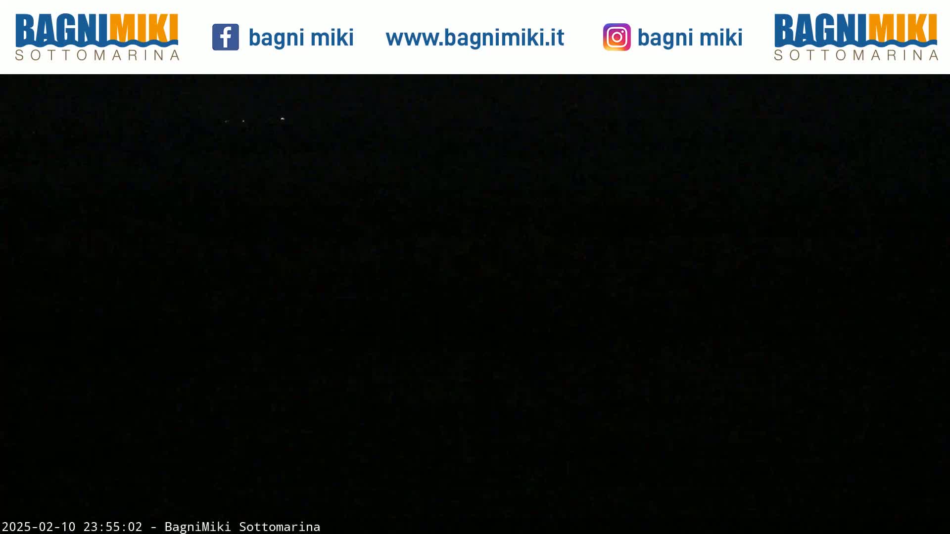 A nighttime image shows a completely dark scene with a few faint lights visible in the distance.