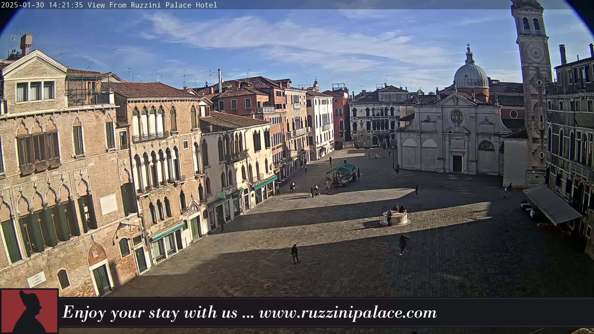 A sunny day reveals a large, mostly empty plaza in Venice, Italy, surrounded by historic buildings, including a church with a dome and a tall bell tower.