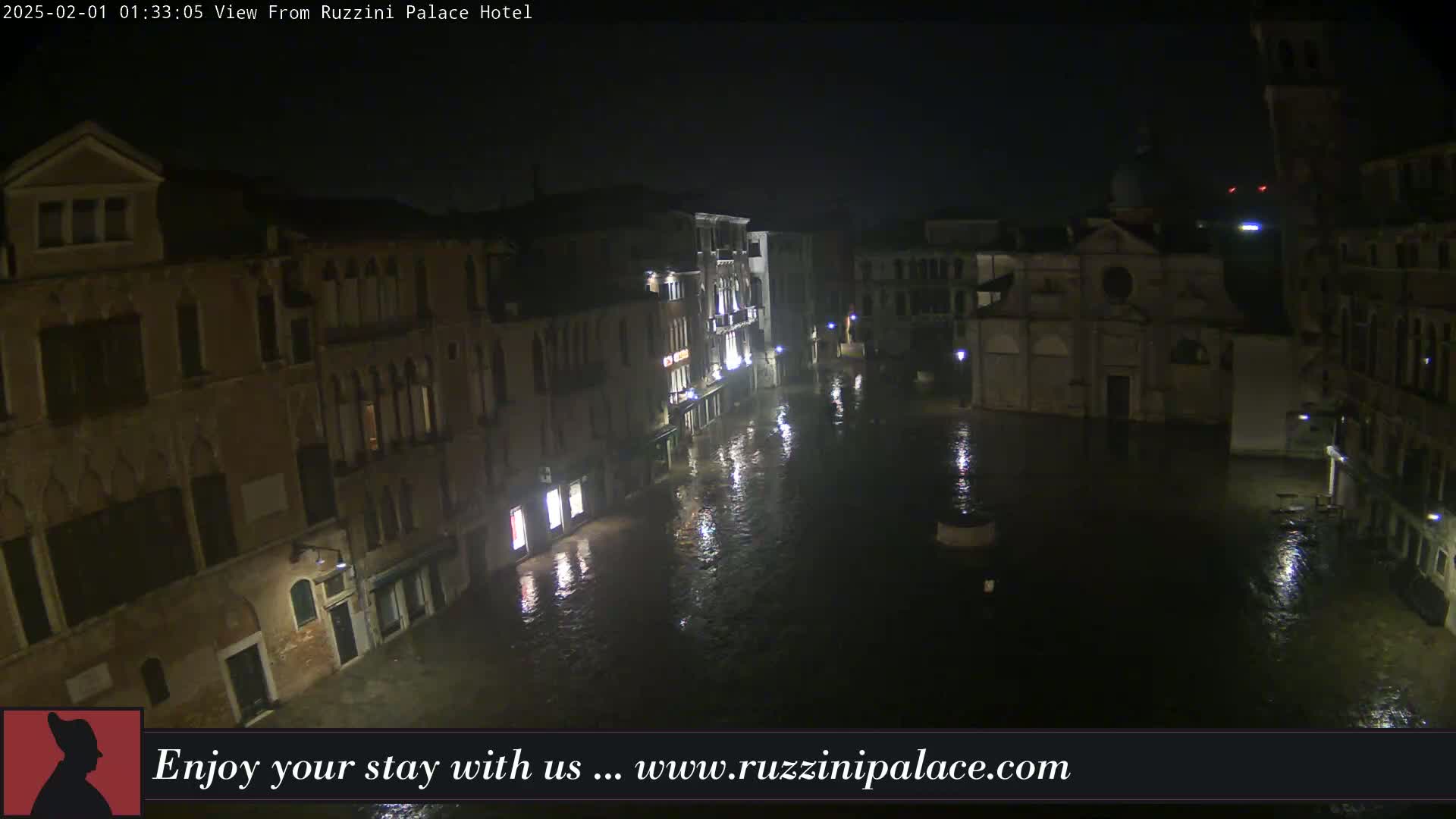 A nighttime view shows a flooded Venetian square surrounded by buildings under a dark, possibly rainy sky.