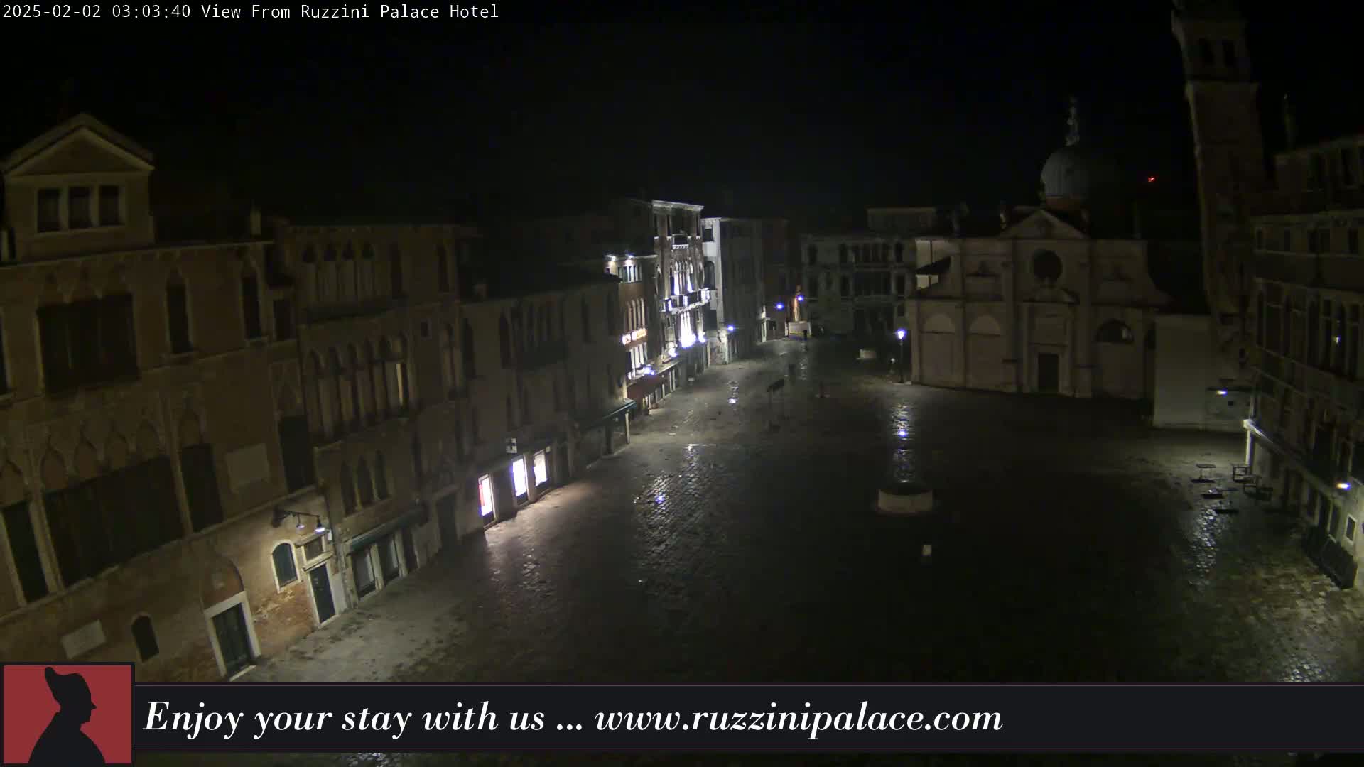 A dark, wet, nighttime view of a cobblestone plaza in Venice, surrounded by old buildings with dim lights.