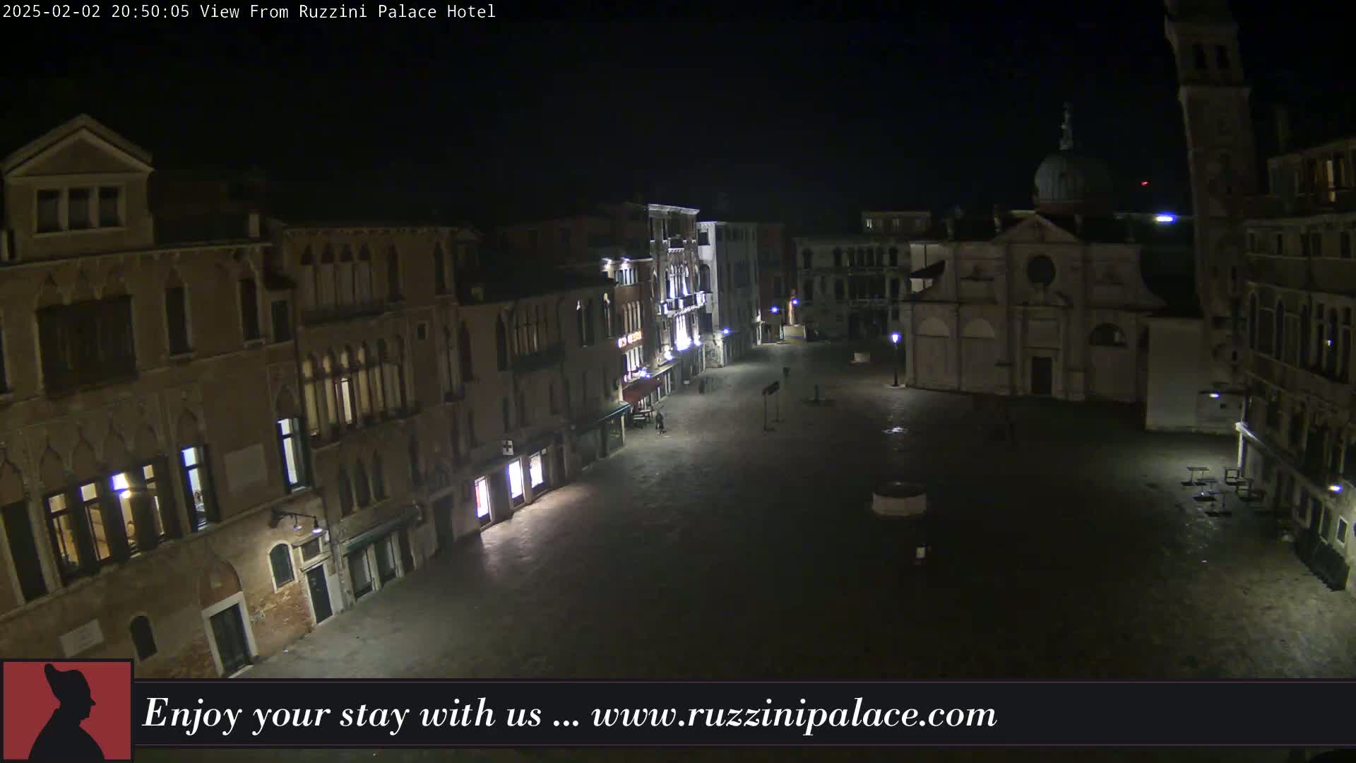A nighttime view of a dark, empty square in Venice, surrounded by old buildings.