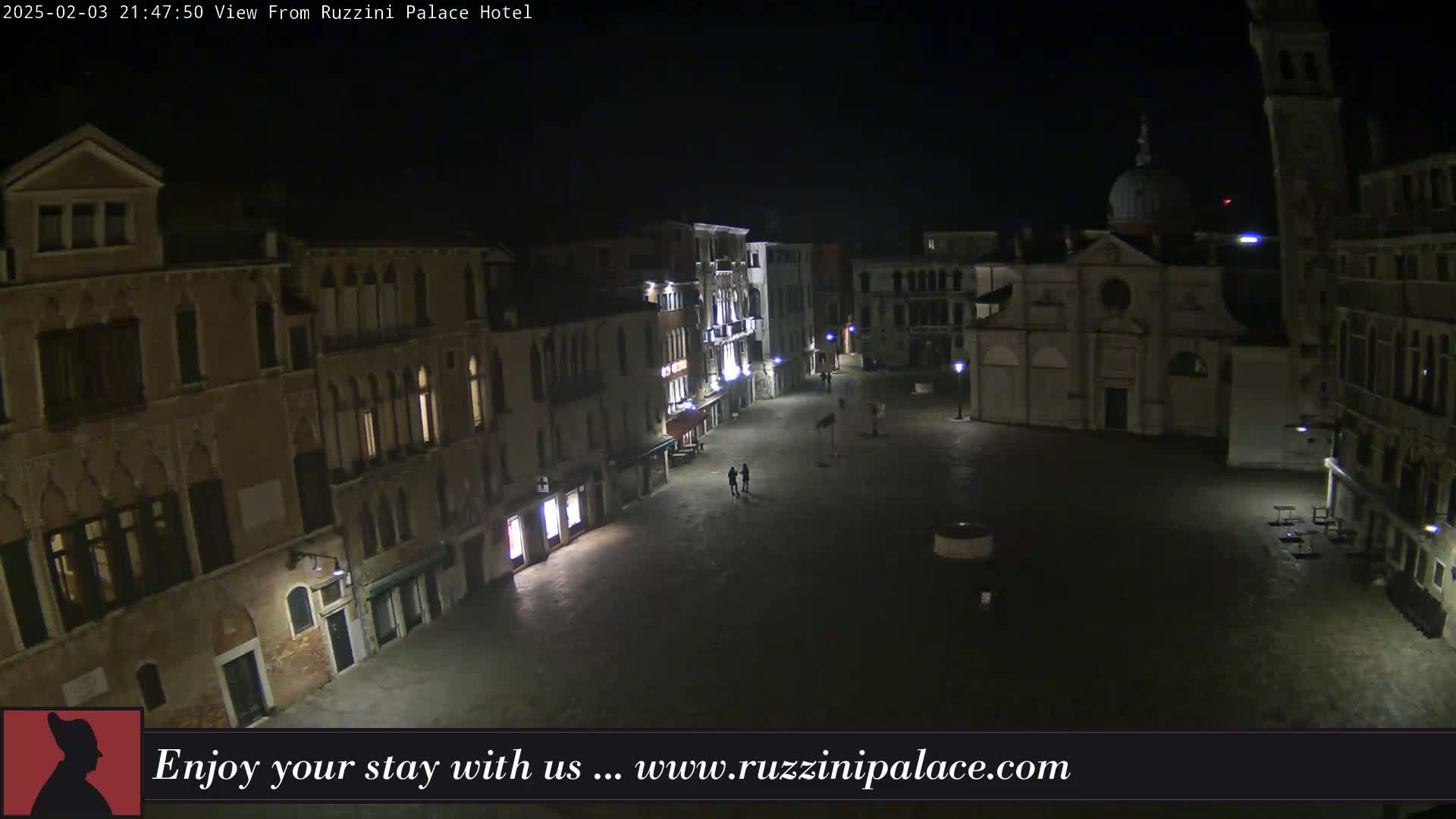 A nighttime view of a dimly lit, empty square in Venice, surrounded by old buildings.