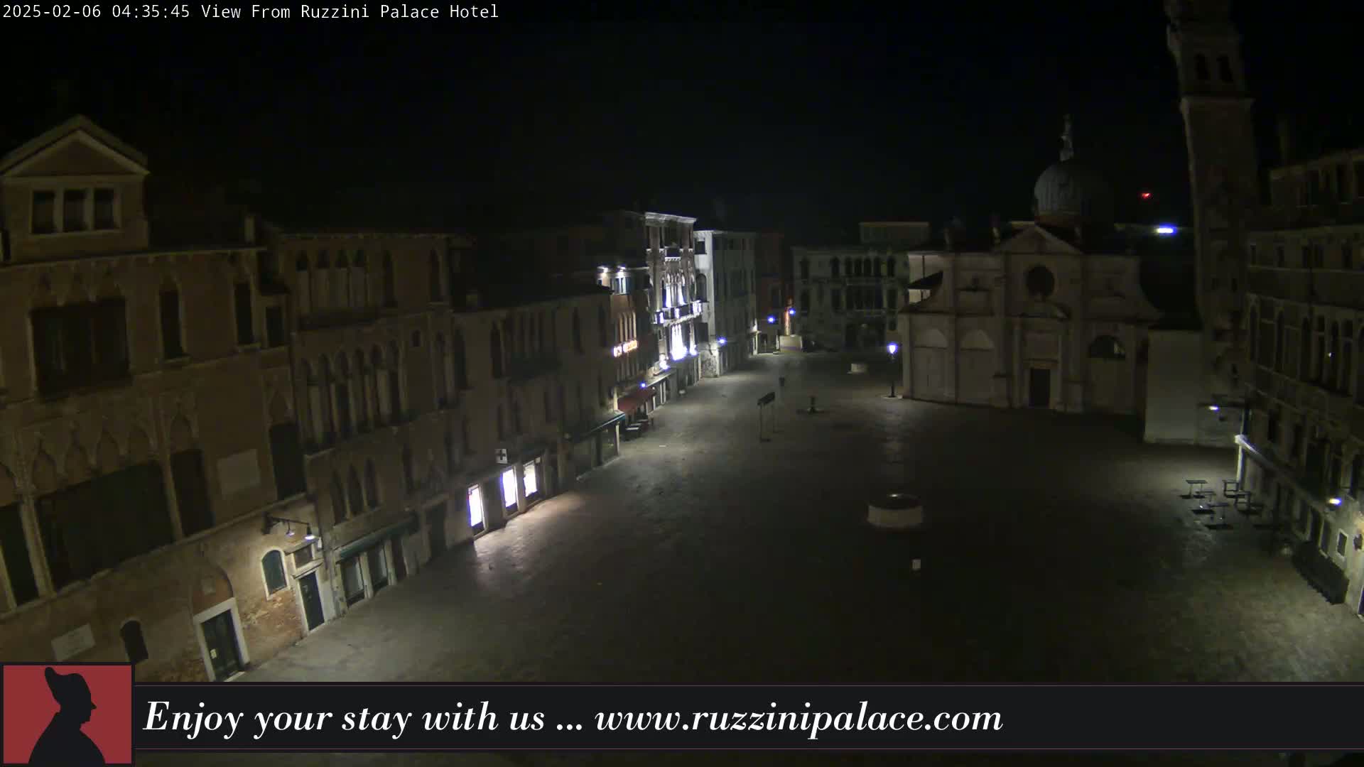 A nighttime view of a mostly empty cobblestone square in Venice, Italy, surrounded by historic buildings.