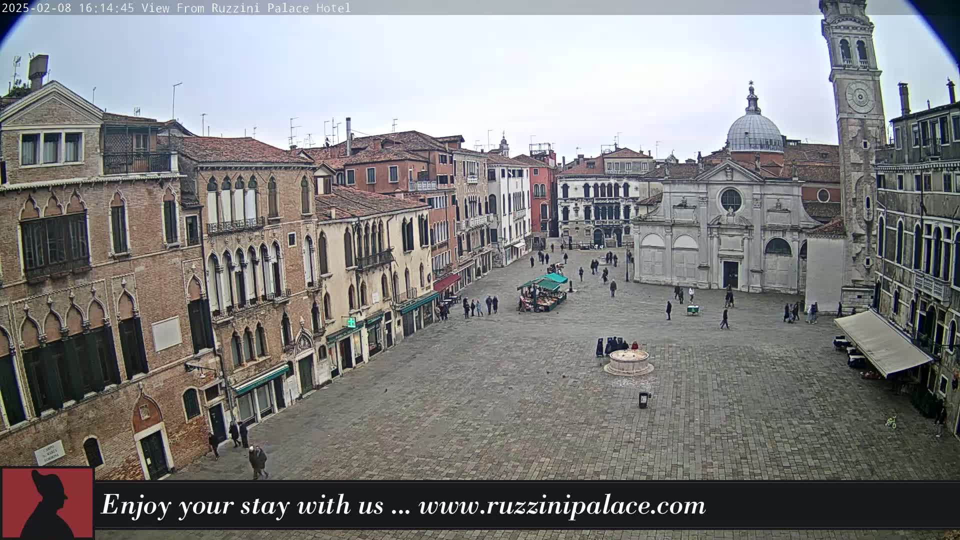 A mostly empty cobblestone square in Venice, surrounded by aged brick buildings under an overcast sky.