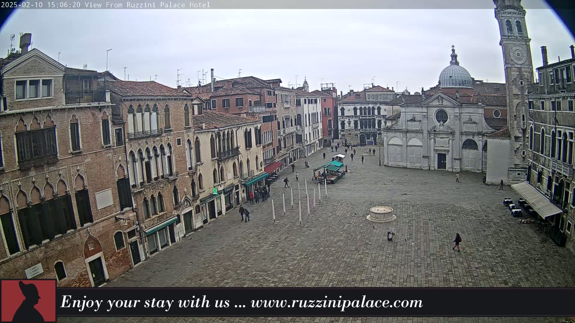 A large, mostly empty square in Venice, Italy, is surrounded by old brick buildings on an overcast day.