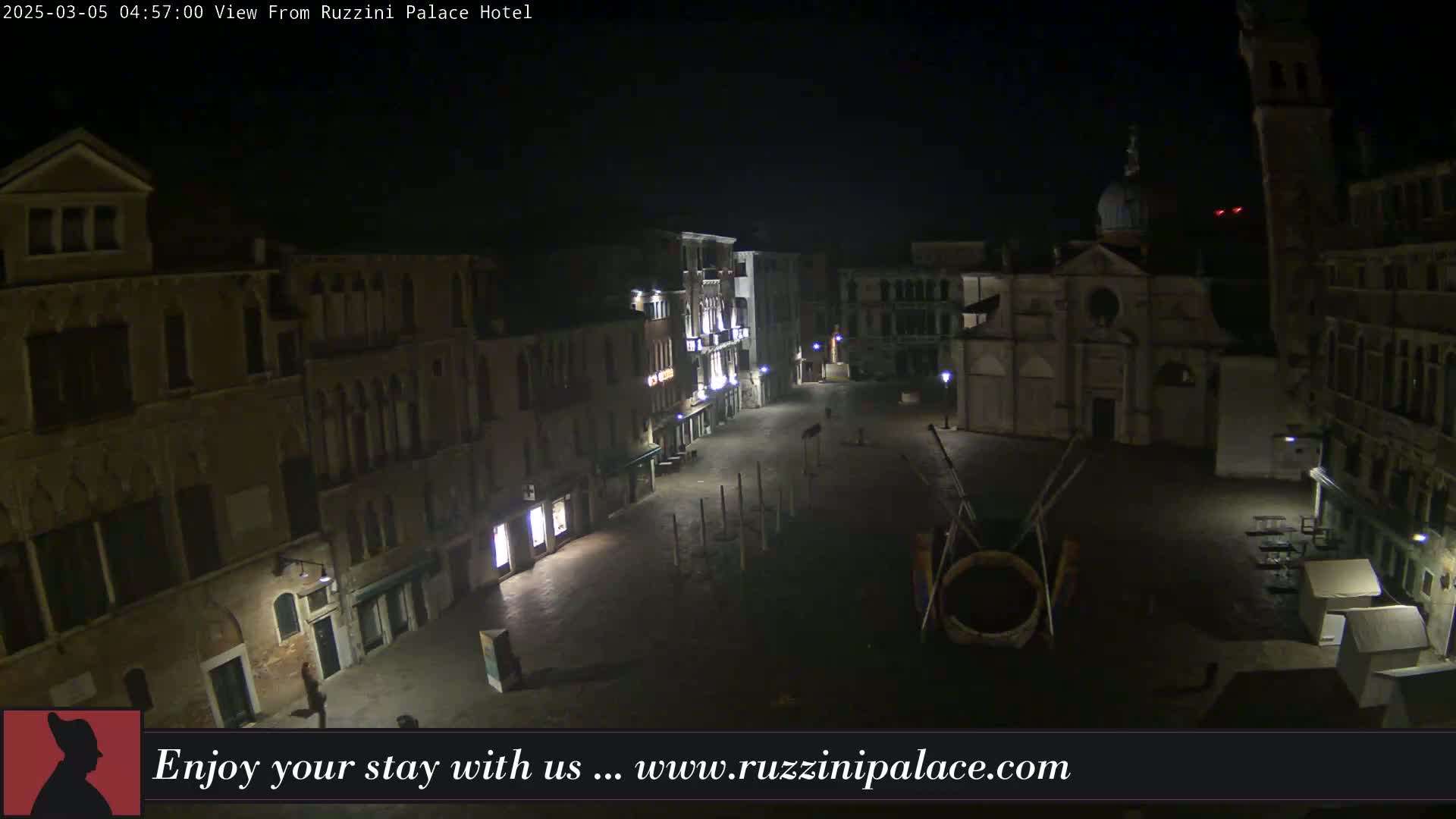 A nighttime, high-angle view shows a sparsely populated Venetian square surrounded by old buildings.
