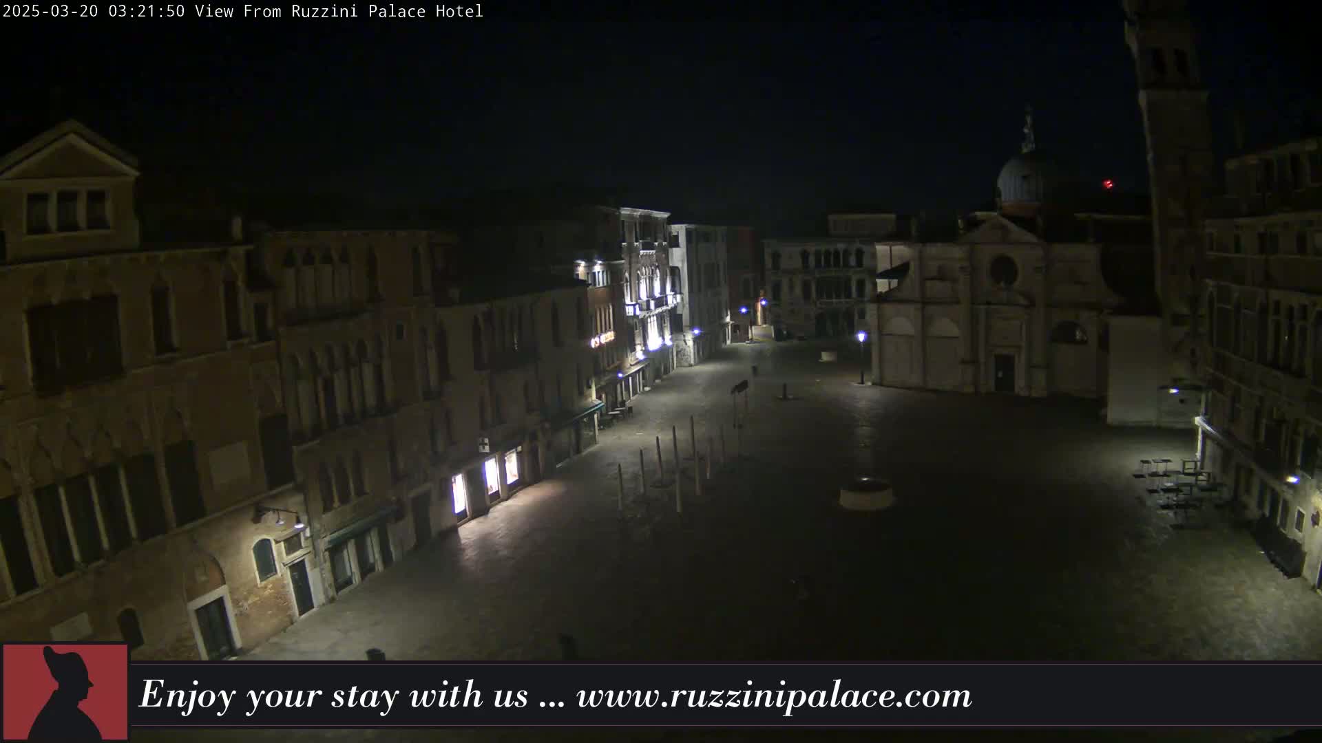 A nighttime, aerial view of a deserted plaza in Venice, Italy, surrounded by old buildings.