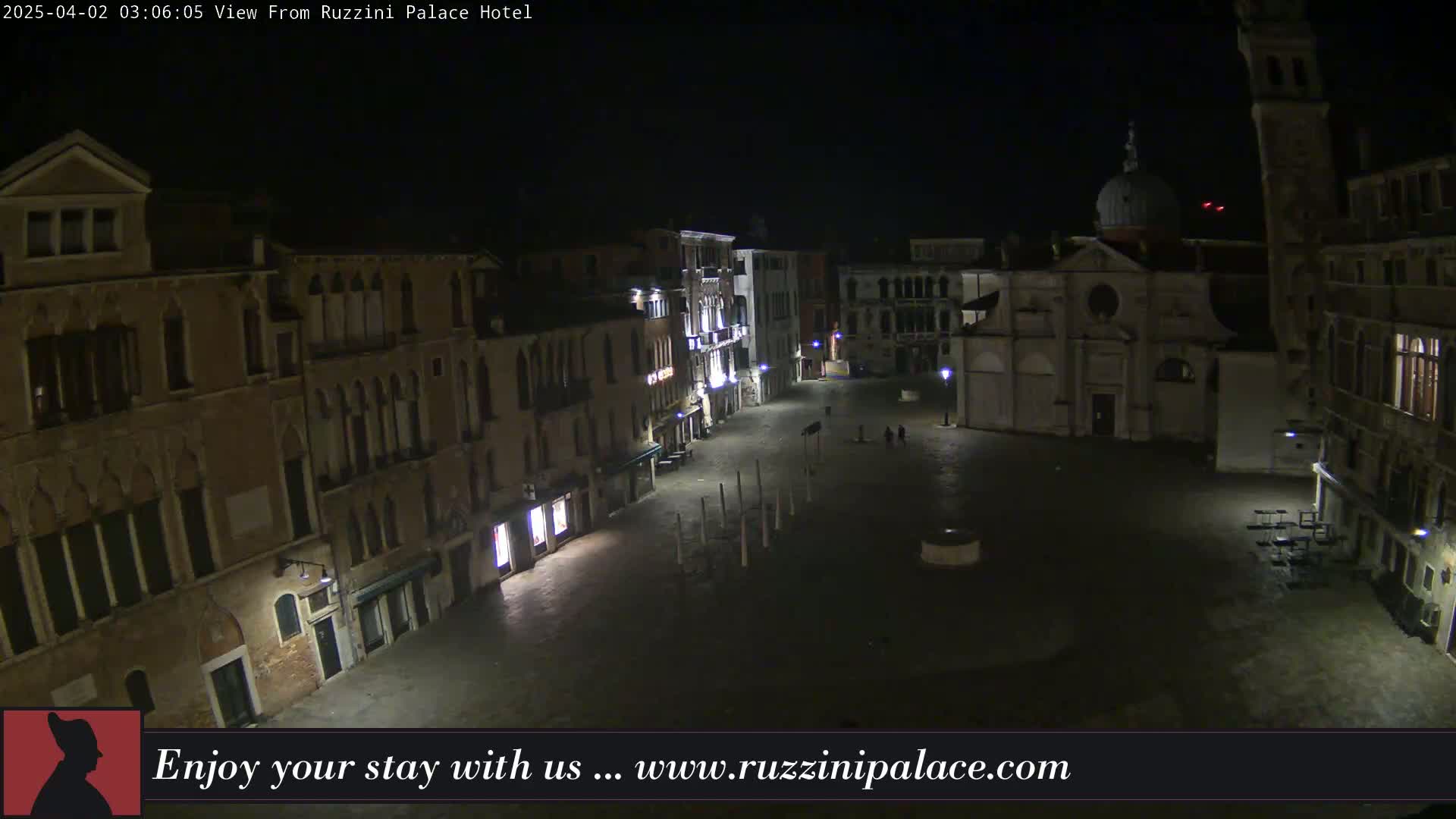A nighttime view of a sparsely populated plaza in Venice, Italy, surrounded by old buildings.