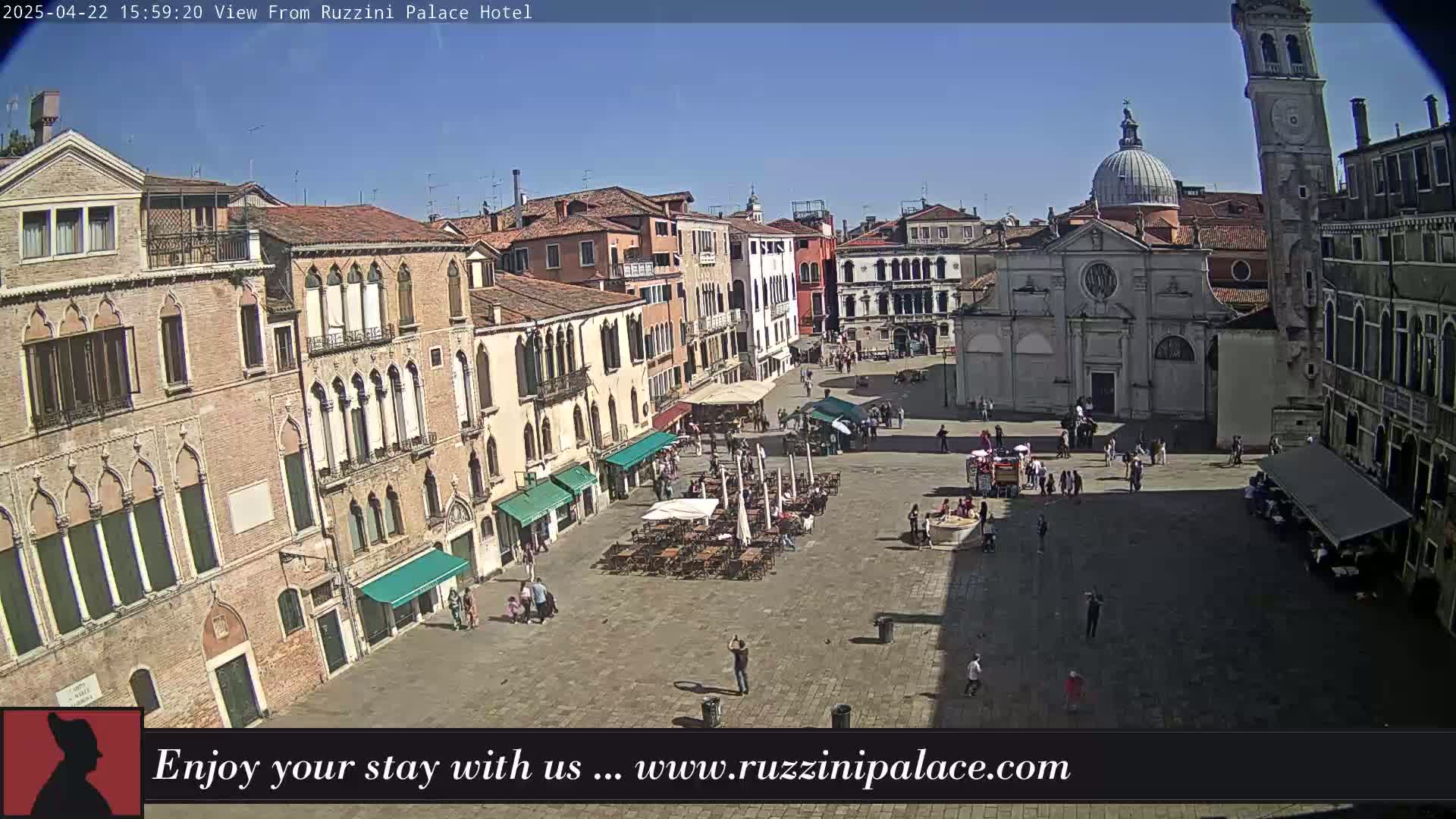 A sunny day in a large, paved square in Venice, Italy, surrounded by historic buildings and a few people.