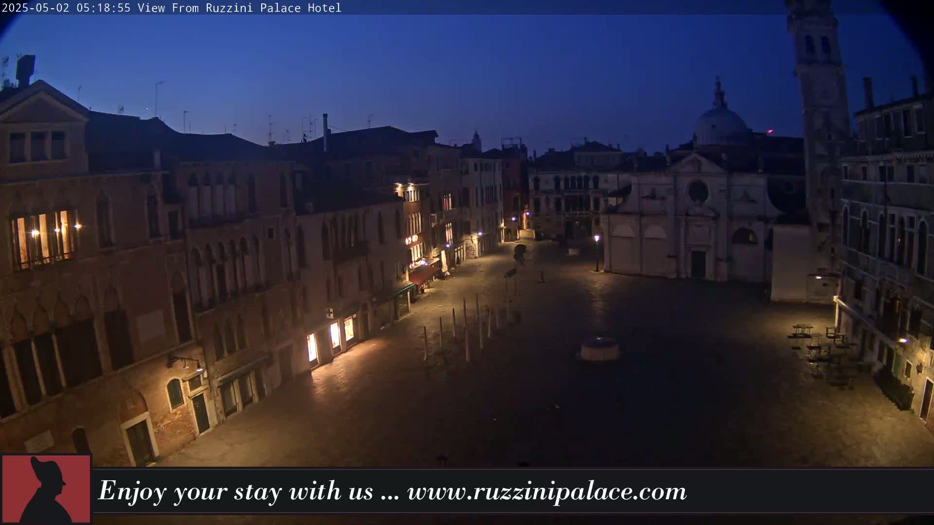 A dark, twilight view of a mostly empty Venetian square surrounded by old buildings.
