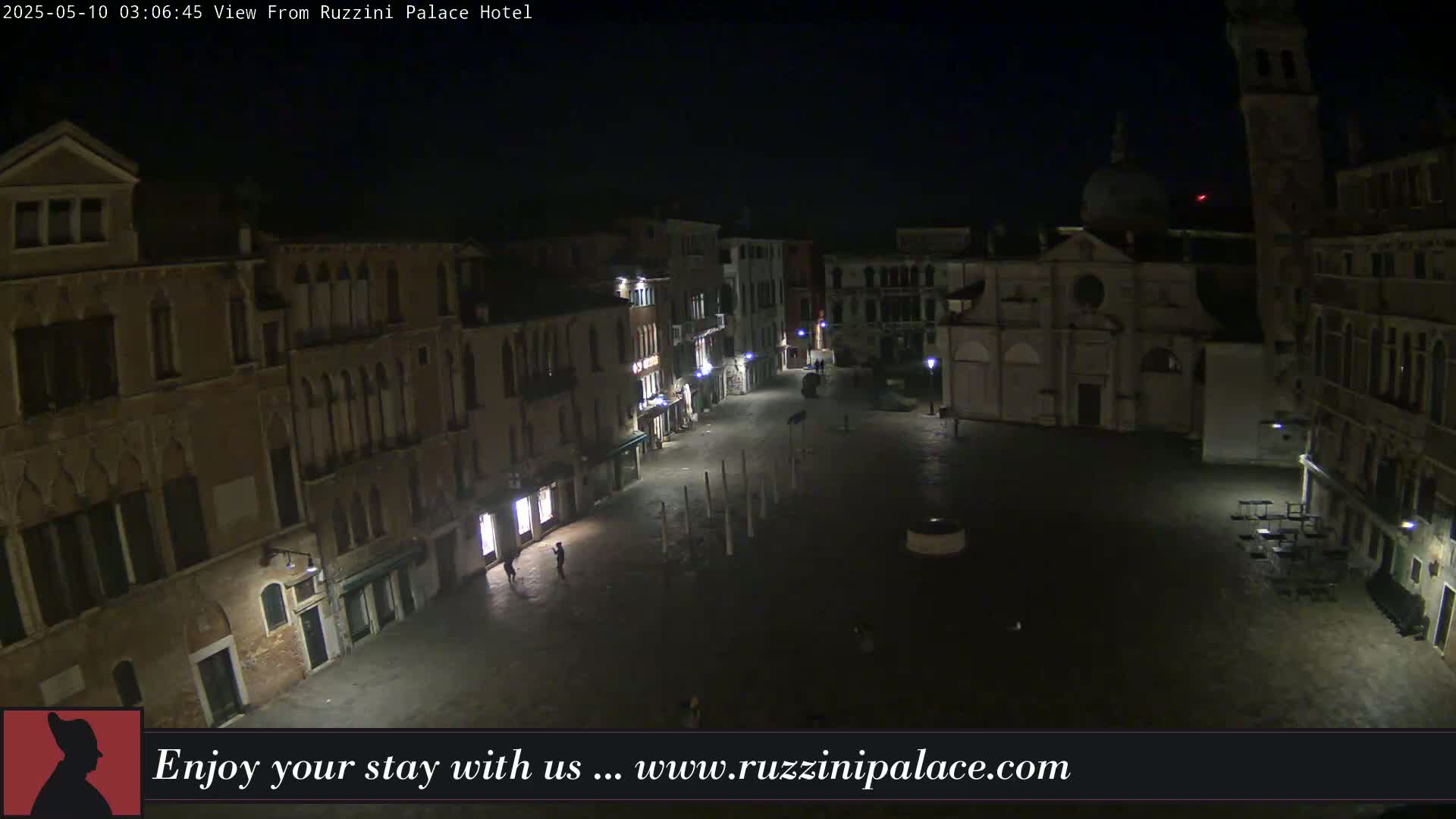A nighttime view of a dimly lit, empty square in Venice, surrounded by old buildings.