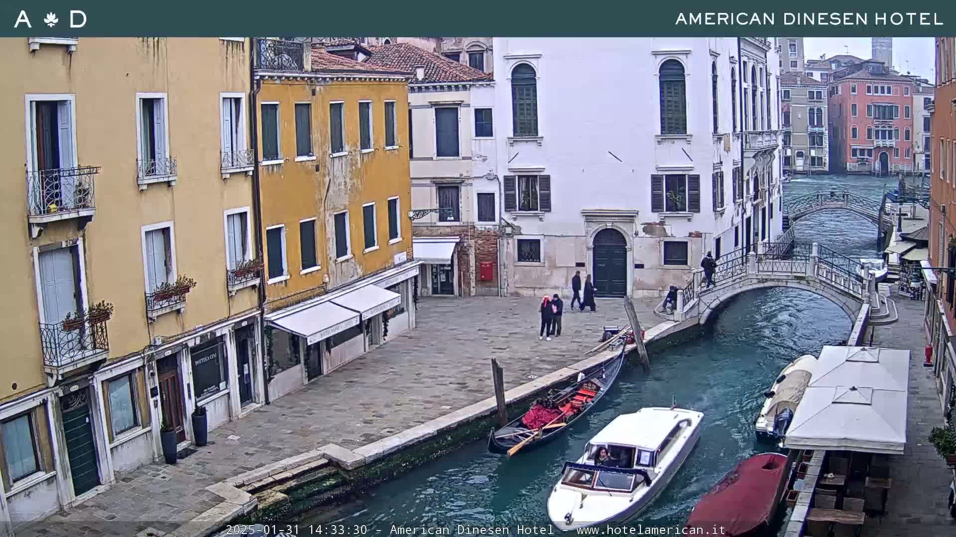 A gondola and a motorboat are on a canal in Venice, Italy,  between buildings on a cloudy day.
