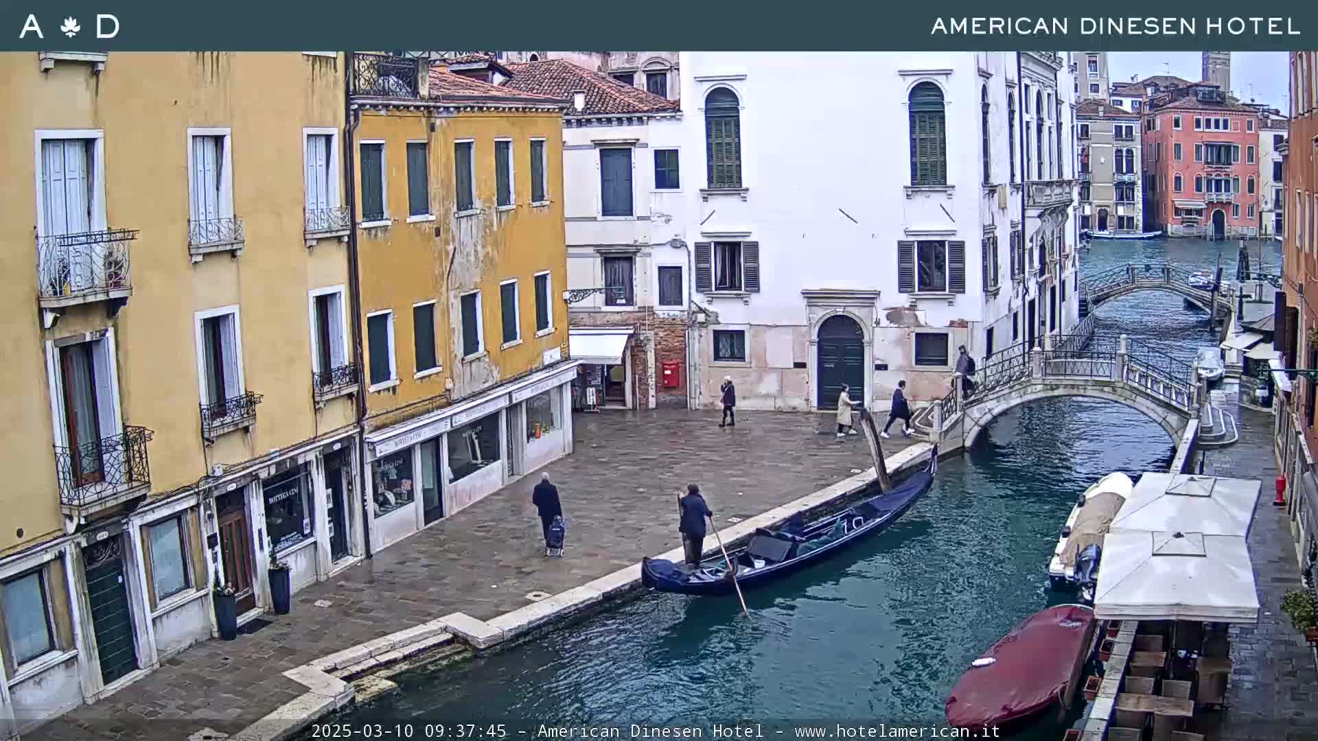 A gondola floats in a canal alongside several buildings in Venice, under a cloudy sky.